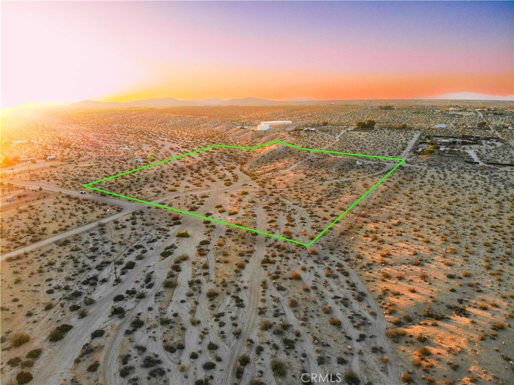 Offered to you is a magical Joshua Tree View lot. Located 7 Minutes north of the Village of Joshua Tree away from the Hwy and the hum. 10 Acres with 2 Entrance points and a private driveway connecting through. Power connection is available on two sides and water lines boarder the property on two side, very rare for a lot of this size or any size. Perched on a crest of a bajada a small shed holds vigil for the perfect place to realize a well appointed home. looking to the west a near by mountain provides a seat for the setting sun to rest streaming with twilight. To the East the endless horizon brings the full spectrum of colors at days end. The southern view looms over the mountains of Joshua Tree National Park the Panoramic vista painted daily by the sky's reflection. Below an arroyo reminds us of the seasons of rain and provides a safe path for wild creatures to cross on to the northern expanse and beside it another place to appoint a mindful casita to view them. Ask about financing options!