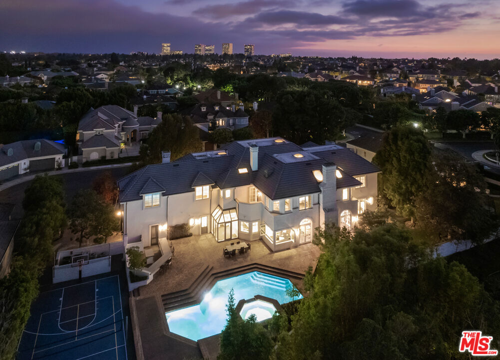 Located in the heart of Newport Beach in the prestigious Belcourt gated community sits this impressive, one-of-a-kind estate at the end of a quiet cul-de-sac. Set on over half an acre of well-manicured grounds, the home boasts an impressive ~8,200sf of livable space with 5 bedrooms and 6.5 bathrooms. A dramatic two-story foyer instantly captivates your attention toward an architecturally profound floating staircase. The property offers a well thought out and conducive floor plan designed for those that appreciate quality and comfort. The main level showcases an impressive formal living room, office, family room with a built-in bar equipped with folding glass paneled windows, formal dining room, and a gourmet chef's kitchen that features top-of-the-line appliances, an expansive center island, butler's pantry, and a breakfast room with tons of bright, natural light. Glide up to the second level where you can find three additional ensuite bedrooms, a spacious bonus room, and the primary suite that includes a fireplace, attached deck overlooking the impressive grounds, and a spa-like bathroom with two separate restrooms, a sauna, and palatial walk-in closet. The resort-style backyard includes a glistening pool and spa, outdoor kitchen and BBQ area, full basketball and volleyball court, and a beautifully manicured yard for endless entertaining. Recent upgrades include new oak and marble flooring, new custom carpets in bedrooms, solid wood paneling with tasteful accent walls done with custom craftsmanship, designer counter tops, designer backsplash, premium quality appliances and brilliant chandeliers.
