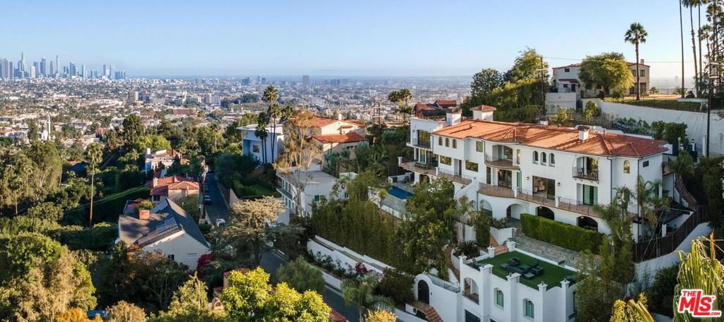 Welcome to "Villa De Bonvue", a masterfully renovated Mediterranean estate perched on a promontory in the prestigious Los Feliz Hills offering jaw-dropping panoramic views from the lush canyons to the glittering skyline of DTLA. Set on a rare street-to-street lot with seven car garage and gated motor court, this architectural gem captures commanding vistas from nearly every room, enhanced by full-length balconies and a rooftop deck designed to frame the city's most iconic landscapes. Every inch of this residence has been thoughtfully curated with luxury in mind featuring white honed travertine, European oak flooring, Italian-imported Bonotti marble, Calacatta Gold countertops, and custom oak and Zebrawood cabinetry. The primary suite is a showstopper with wraparound views, dual spa-inspired bathrooms, a soaking tub, steam and horizontal showers, and boutique-style closets. Unmatched amenities include a movie theater, bowling alley, game room, fitness center, wellness studio, salon, multiple kitchens including a chef's kitchen, and a resort-style infinity pool and spa. A detached guest house adds versatility for hosting or multigenerational living. Within close proximity to Netflix HQ, Griffith Park, The Greek Theatre, and all the best dining, culture, and nightlife in Los Feliz and Hollywood. At only $750 a foot, this exceptional compound is arguably the best value in all of the Los Feliz Hills for a home of this caliber. Truly a unbeatable opportunity for the most discerning of buyers.