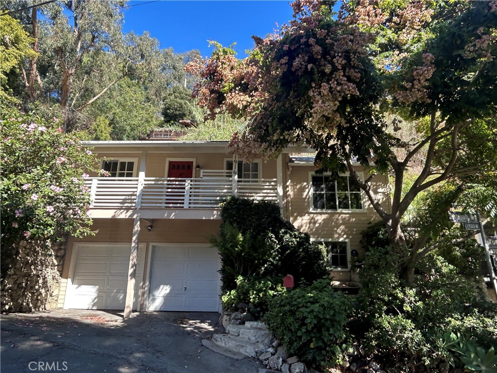 Nestled in the heart of Laurel Canyon, 1916 Weepah Way is a charming bungalow retreat offering 2 bedrooms and 1 full bathroom. Elevated above the street, this home enjoys partial canyon views.  Inside, the residence is a spacious living area, large windows and a cozy decorative fireplace.  The oversized kitchen includes red marble countertops, a vintage stove, and ample cabinetry for storage. Adjacent to the kitchen is the dining area with built-ins.  Outdoor spaces include a wraparound brick patio with stone planters, perfect for outdoor enjoyment.  The ground level features a one-car garage or basement space with a bonus room that can be used for a home office,  plus a laundry area with washer and dryer. A double parking apron in front of the garage provides additional parking.  Heating and AC are provided by a mini-split system along with a heater insert in the decorative fireplace. The home sits above the garage with the entrance on the second level, offering added privacy.  Located in the Hollywood Hills, this home delivers the best of both worlds, a tranquil canyon setting with easy access to the Valley and the Westside.