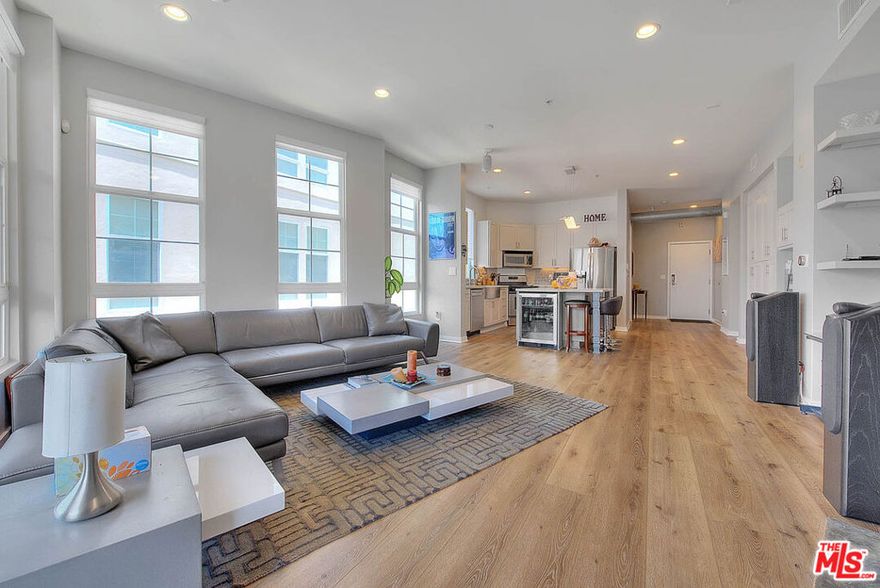 Welcome to The Lofts at Playa Vista, where industrial chic meets coastal luxury. This rare, light-filled end unit showcases the largest floor plan in the building (approx. 1,440 sq.ft.) with soaring 10-ft ceilings, exposed ductwork, and stylish modern updates throughout. Beautifully remodeled by the original owner, this 3-bedroom, 2-bath home offers an open-concept layout with new luxury vinyl plank flooring, designer lighting, and custom finishes that elevate every space. The gourmet kitchen features granite countertops, a center island with dual faucets, stainless steel appliances, and a farmhouse sink, perfect for entertaining. Relax in the spacious living area with a concrete accent fireplace and reclaimed wood mantle, or retreat to the luxurious primary suite with a walk-in custom closet and spa-inspired bath with steam shower, rain head, and dual vanities. Enjoy your private balcony with ambient lighting, ideal for BBQs or quiet evenings. Additional highlights include motorized sheer shade window treatments, fresh paint, and dual-pane windows for comfort and efficiency. Residents of Playa Vista enjoy resort-style living with access to multiple pools, spas, fitness centers, sport courts, dog parks, playgrounds, and beach shuttles. Located across from Concert Park  with restaurants, cafes, and neighborhood favorites like The Gulp and Coffee Bean steps away, this home offers the perfect blend of style, space, and convenience. Includes 2 side-by-side parking spaces, guest parking, and all the amenities that make Playa Vista one of L.A.'s most desirable communities.