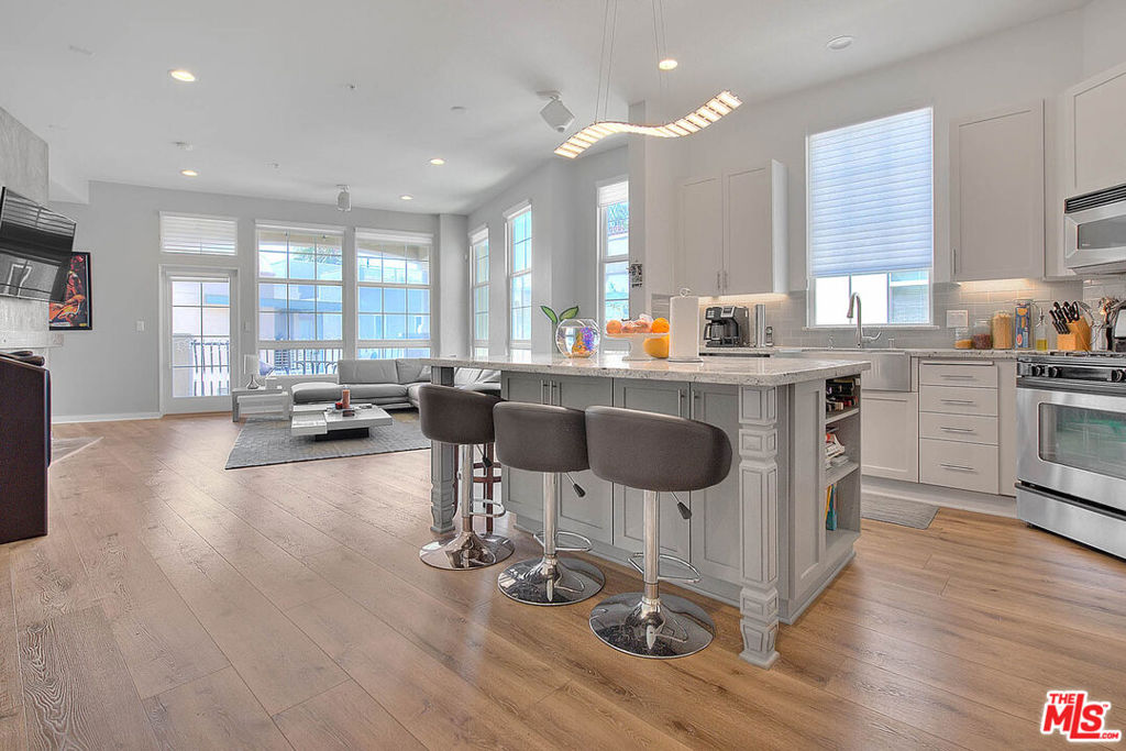Welcome to one of the most sought-after units at The Lofts at Playa Vista! This stunning, light-filled end unit boasts the largest floor plan in the building with soaring 10-foot ceilings, exposed ductwork, and contemporary industrial character throughout. Fully remodeled and meticulously maintained by the original owner, this 3-bedroom, 2-bathroom loft features: A spacious open-concept layout with new luxury vinyl plank flooring and designer finishes. A gourmet center island kitchen with granite countertops, stainless steel appliances, farmhouse sink, and double faucet. A stylish living room with concrete accent fireplace and reclaimed wood mantle. A luxurious primary suite with walk-in custom closet and spa-like bath featuring a steam shower, rain head, and dual vanities. Custom motorized window treatments, fresh paint, and double-pane windows for energy efficiency. A private balcony with string lighting perfect for BBQs and relaxing evenings. Enjoy resort-style amenities: access to pools, spas, fitness centers, sport courts, dog parks, playgrounds, and summer shuttles to the beach. Ideally located directly across from Concert Park, with events, eateries, The Gulp Brewery, Coffee Bean, and more just steps away. Includes 2 side-by-side parking spaces in a secure garage, guest parking, and all the conveniences of Playa Vista living.