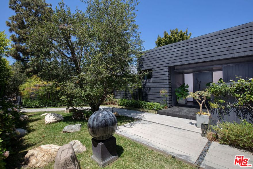 Striking, extensively remodeled, hedged and gated 1960's single story Contemporary in prime, North of Sunset, Brentwood location. Completed for the current owner by award-winning architects DESIGNARC with open floor plan, clean lines, airy, sun-filled spaces, vaulted ceilings, wood floors, rich wood paneling, walls of glass & French doors throughout. All rooms overlook greenery and open to lush, very private wrap-around garden with patios, fountains, lawn and mature foliage. Open living room with fireplace, family room, generous dining area and fabulous Arclinea cook's kitchen are all bathed in natural light with soaring ceilings and beautiful views of the garden. Five en-suite bedrooms including exceptional owner's suite with pitched ceiling, fireplace, marble bath, large fitted closet, private terrace and lovely views of the garden.  Wonderful drama, detail and quality of workmanship and materials throughout. An absolute gem in an extremely desirable neighborhood within close proximity to shops, restaurants and all the best Westside schools.