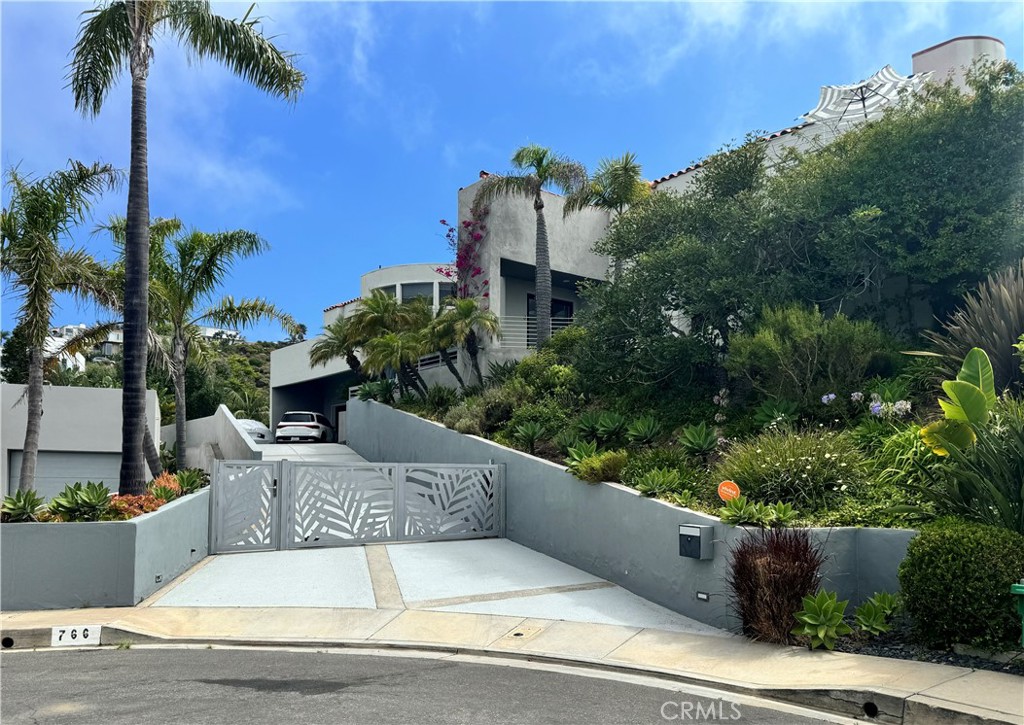 Massive Lot, Private Cul-de-sac, Ocean Views Grandeur | Your Laguna Beach Oasis
Discover unparalleled luxury at 766 Pelican Drive, an exquisite estate in Portafinã, the heart of Laguna Beach. An architectural gem designed by award winning architects Marca Weston Whitfield, this custom soft contemporary home features creative use of angles and curves making the exterior design and every room a work of art boasting breathtaking panoramic views that will leave you captivated.
Immerse yourself in refined living spaces adorned with Brand Van Edmond lighting, pristine finishes, creating an atmosphere of sophistication and tranquility. The gourmet kitchen is a chef's dream, featuring top-of-the-line appliances and a spacious bar perfect for culinary exploration. Unwind in the luxurious spa-like bathrooms, including a primary suite oasis complete with a rejuvenating steam shower. Experience the ultimate in indoor-outdoor living as you seamlessly transition from the elegant interiors to the sun-kissed terraces. Step outside to your massive private outdoor sanctuary, where a Jacuzzi and fire pit beckon relaxation. Lush landscaping and mature fruit trees create a serene ambiance among a massive lot. Recent upgrades include energy-efficient Anderson windows and custom powered blinds enhancing both comfort and style. Located at the end of a cul-de-sac with ample parking, a 3 car garage and gated extended driveway. This extraordinary property offers an unparalleled opportunity to experience the epitome of Laguna Beach living with world-class dining, shopping, and entertainment just moments away.