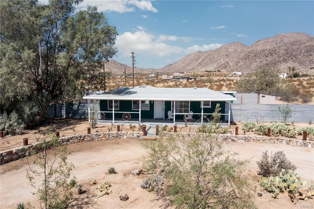 Mid Century Joshua Tree Pad with Private Mountain views! Welcome to Casa Verde—a stylish, sun-drenched retreat tucked away on the last paved street below the stunning Bartlett Mountains. With a wide-open parcel to the north and few neighbors beyond, this home offers rare privacy, panoramic views, and the feeling of being worlds away—yet you're just minutes from downtown Joshua Tree and the National Park. Inside, the open-concept layout is filled with natural light and flows effortlessly from the living and dining areas into a sleek, updated galley kitchen. The extra-large primary suite is a true sanctuary, complemented by two additional well-appointed bedrooms. Brand new $1500 EV charger installed! Outdoors, enjoy seamless indoor-outdoor living with a spacious front porch shaded by a towering desert pine and a wide covered back patio featuring a hot tub deck, privacy fencing, al fresco dining, and stargazing hammocks. A detached bonus casita offers flexible space for guest overflow, creative use, or added rental potential—expanding both comfort and value. Thoughtful upgrades include new 200 & 70 AMP panels, mini splits, and an 8'x6' Tuff Shed with brand new washer/dryer. Casa Verde blends elevated design with peaceful desert living in one of Joshua Tree’s most coveted locations.