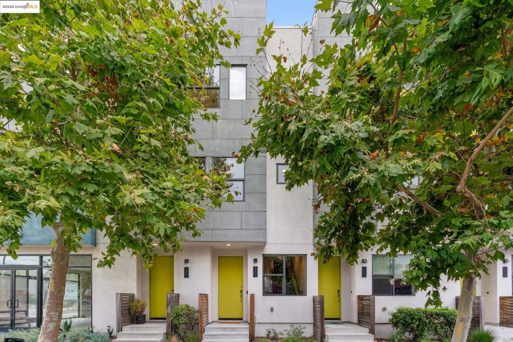 Experience modern urban living at 1405 Wood Street in Station House. This solar-powered, energy-efficient corner-unit townhouse offers 2 bdrms, 2.5 baths, and 1,504 sqft of move-in ready space—one of the community’s largest 2-bedroom floor plans. Throughout the home, enjoy abundant natural light, upgraded wood flooring, luxury ceramic tile (no carpet!), and freshly painted walls. The main level is designed for entertaining with high ceilings, spacious living room, formal dining area, and sleek kitchen featuring quartz countertops, SS appliances, and a generous island. Upstairs, 2 ensuite bdrms include an expansive primary suite with custom closet system, along with a second suite offering its own private bath. A convenient laundry room on the same floor is outfitted with jumbo Samsung W&D for everyday ease. Additional features include a Nest thermostat, central AC/heat, dual-pane windows, recessed lighting, and an attached one-car garage with overhead+bike storage. With low HOA dues, guest parking, and abundant street parking right outside your door, convenience is built in. Located in vibrant West Oakland near Prescott Market, Pacific Pipe climbing gym, Michelin-starred dining, BART, and freeway/Bay Bridge access, this home perfectly unites modern sustainability and city living.
