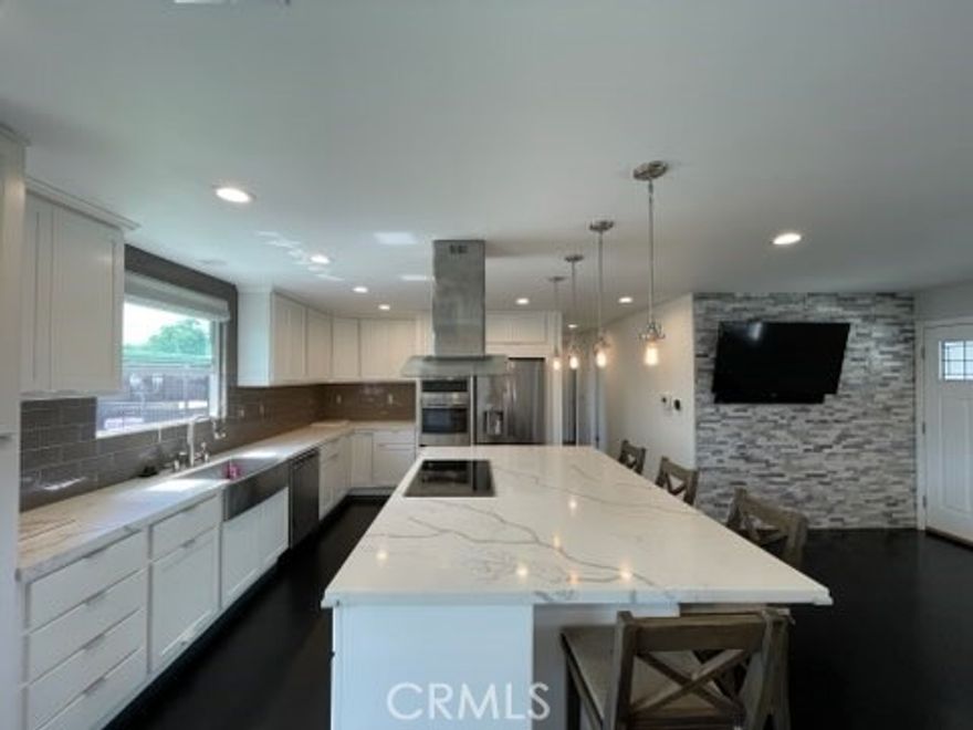 This single-story residence is where comfort meets coastal convenience, just 2.8 miles from the shores of Huntington Beach. The updated home greets one with a fully fenced front yard, offering a spacious lawn for one to enjoy. A two-car garage provides ample parking and includes a washer and dryer for added convenience. The front porch is an ideal spot to begin the morning with a cup of coffee or wind down in the evening. Upon entering, one is welcomed by an open-concept living area filled with natural light and warmth. The kitchen has a spacious island featuring an electric cooktop and seating area- perfect for gathering and sharing meals. With cabinetry, a built-in oven, dishwasher, beverage fridge and refrigerator included in the lease, the space blends practicality with comfort. From the kitchen sink, one can look out the window to the backyard, where an above-ground jacuzzi invites relaxation. The hallway leads to two comfortable bedrooms and a well-appointed bathroom, while the primary bedroom offers the comfort of a private en-suite bath. Ideally located near the Seal Beach National Wildlife Refuge, Marina Park, and within walking distance to Village View Elementary School, this home offers both tranquility and connection to the best of coastal living.