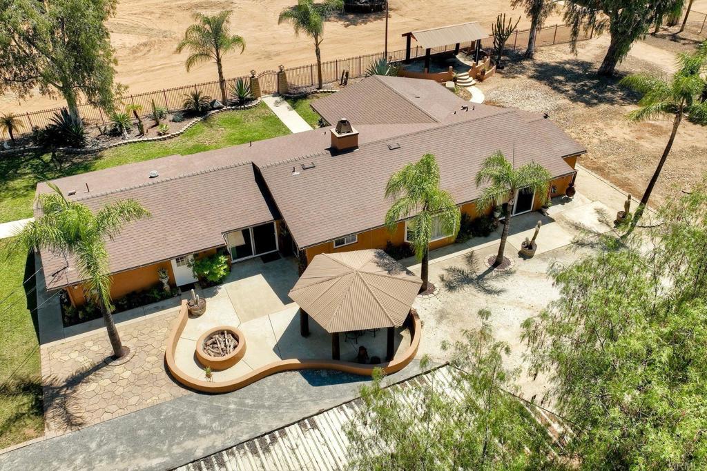 Centrally located spectacular horse property on a totally flat and double fenced 3 acres lot, former equestrian training facility, great potential and privacy. The single-story CA-ranch style home has been updated with new roof, dual-pane windows and doors, newer baths, kitchen, 2 master suites, ceramic tile and carpet floors. Open home office, perfect for in-home business. Big 4,200 Sq.Ft. (70'x60') metal barn/stable on concrete slab with room for many stalls, RV parking, wash-rack, turn-outs, off-road vehicle track, play-yard. Equestrian arena's fence got removed but could be built back, covered trainer-view deck. Great patio for entertaining along with huge front and rear yards. Patio w/ firepit. All electric home. Easy access to trails. Front 2 gates and one back gate access. Less than 5 min to Valley Center's schools, dining and shopping.