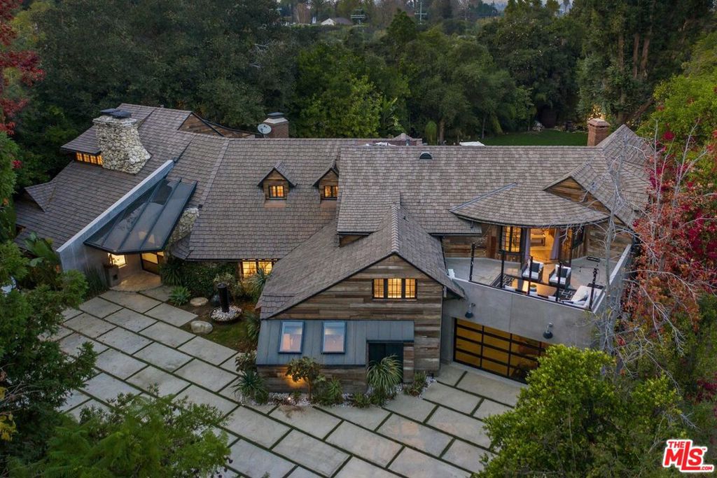 Set behind gates, this ultra private contemporary compound is nestled up a quiet tree lined street in the exclusive Rancho Estates. Completely remastered and remodeled, the home features a beautiful living room, a family room with a custom bar, a bonus room, office, fully equipped chefs kitchen and both formal and informal dining. The incredible master suite boasting views of the property showcases a spacious spa like bathroom and large walk in closet. Outfitted with reclaimed wood siding, vaulted ceilings, exquisite lighting, elegant hardwood floors, marble counter tops, and Italian finishes, the home is a true architectural masterpiece. Second to none, the expansive grounds host a large pool, ample lounge/entertaining space, grass area, an amazing outdoor Grotto Kitchen and a detached guest house with a full bedroom, bathroom, and complete view of the property.