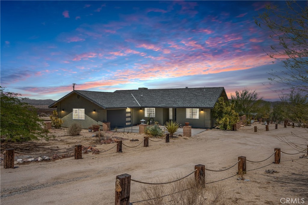 Welcome to your desert oasis in 29 Palms! Perfectly situated in the sought-after Sherman Heights area and just minutes from Joshua Tree National Park, this turnkey 4-bedroom, 2-bathroom home offers 1,663 sq. ft. of stylish living on a beautifully landscaped 1.25-acre lot. Whether you’re searching for a primary residence, weekend escape, or high-performing short-term rental, this property delivers comfort, design, and investment potential in one exceptional package. The open-concept living area, anchored by a cozy fireplace, flows seamlessly into the updated kitchen with custom cabinetry, breakfast bar, built-in microwave, and electric oven, while the dining area’s bay window frames sweeping desert views. The spacious primary suite features French doors to the patio, wood-look laminate flooring, dual vanities, and a luxurious soaking tub set beneath picture windows for stunning mountain vistas. Three guest bedrooms, indoor laundry, ceiling fans, dual-pane windows, central HVAC, and evaporative cooling ensure year-round comfort. Outdoors, mature Joshua trees, palm trees, cacti, and desert flora are arranged among rock riverbeds, walking paths, and multiple shaded seating areas, complemented by a putting green, hot tub, outdoor shower, and built-in BBQ island. The converted 2-car garage, now a game room with insulated doors, adds versatility. Currently operating as a successful STR, the home is offered fully furnished with potential annual gross revenue over $74,000 and cap rates up to 8.5% (self-managed) or 7.0% (professionally managed), making it an ideal choice for those seeking a proven income property, a serene getaway, or a unique desert home in one of the area’s most desirable locations.