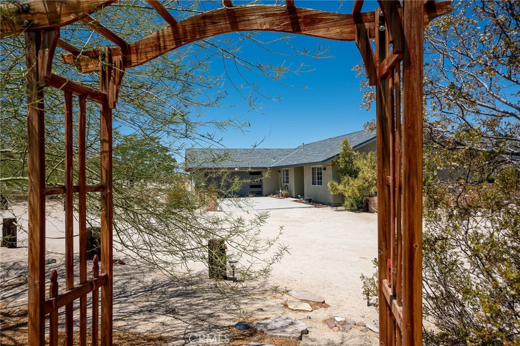 Welcome to your desert oasis in 29 Palms! Perfectly situated in the sought-after Sherman Heights area and just minutes from Joshua Tree National Park, this turnkey 4-bedroom, 2-bathroom home offers 1,663 sq. ft. of stylish living on a beautifully landscaped 1.25-acre lot. Whether you’re searching for a primary residence, weekend escape, or high-performing short-term rental, this property delivers comfort, design, and investment potential in one exceptional package. The open-concept living area, anchored by a cozy fireplace, flows seamlessly into the updated kitchen with custom cabinetry, breakfast bar, built-in microwave, and electric oven, while the dining area’s bay window frames sweeping desert views. The spacious primary suite features French doors to the patio, wood-look laminate flooring, dual vanities, and a luxurious soaking tub set beneath picture windows for stunning mountain vistas. Three guest bedrooms, indoor laundry, ceiling fans, dual-pane windows, central HVAC, and evaporative cooling ensure year-round comfort. Outdoors, mature Joshua trees, palm trees, cacti, and desert flora are arranged among rock riverbeds, walking paths, and multiple shaded seating areas, complemented by a putting green, hot tub, outdoor shower, and built-in BBQ island. The converted 2-car garage, now a game room with insulated doors, adds versatility. Currently operating as a successful STR, the home is offered fully furnished with potential annual gross revenue over $74,000 and cap rates up to 8.5% (self-managed) or 7.0% (professionally managed), making it an ideal choice for those seeking a proven income property, a serene getaway, or a unique desert home in one of the area’s most desirable locations.