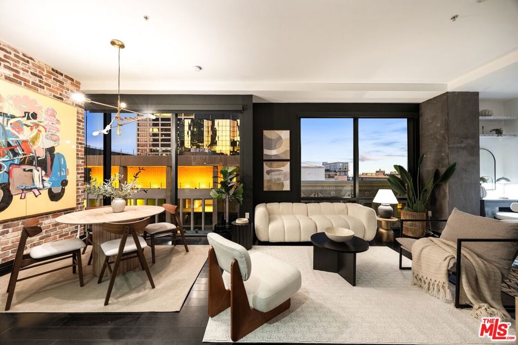 Nestled high on the 14th floor, the highly desirable end unit is a harmonious blend of modern elegance and urban sophistication. True urban dwelling with views of the bustling city down below. The open floor plan loft boasts floor-to-ceiling glass walls, tall gallery walls, 12-foot ceilings and warm dark hardwood floors. 2 unique brick accent walls and an East facing wall painted black. Natural light emanates throughout. The sleek kitchen features blue color cabinetry, white backsplash, granite countertops, stainless steel appliances and a new Bosch dishwasher. The bathroom features a soaking tub. Washer/dryer are included! Building amenities include 24/7 security/concierge, a rooftop sundeck, barbecue, a chic bar with panoramic downtown views, a resident club room, gym and a helicopter pad. 1 unassigned parking space included - in the building with a direct elevator bank to the 14th floor as well as the lobby.Located directly above the 7th Street Metro Station, enjoy the best of urban dwelling at your doorsteps. Walk to the action at Crypto.com Arena or LA Live. Enjoy the best of food and beverages at Javiers and Joyce. Across the street from the Bloc and Joeys. Whole foods is a stone's throw away and the Broad Museum is just a few blocks away. Enjoy rich and diverse dining, world class museums and tons of entertaiment options. Truly, the best location in Downtown L.A.