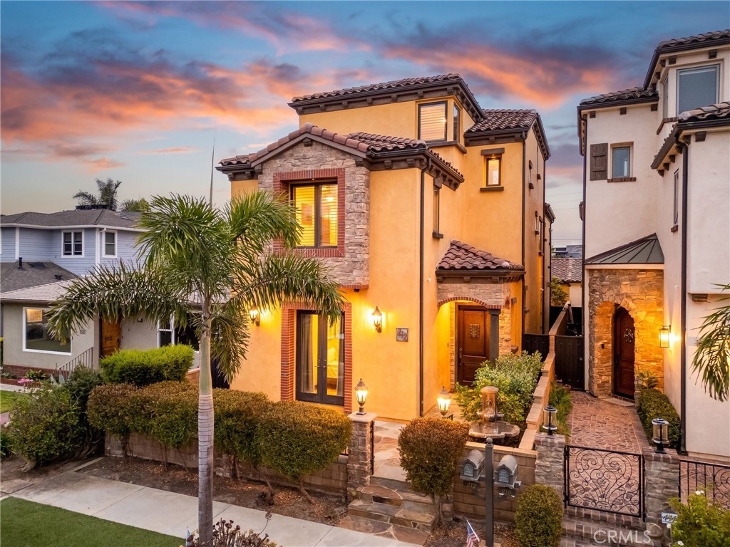 Welcome to the ultimate coastal retreat in the heart of Huntington Beach, where refined design meets relaxed beachside living. Only three blocks from the ocean, Pacific City, Main Street, and world-class resorts, this custom-built three-story home rests on a generous lot along one of downtown’s most peaceful streets, offering the perfect blend of coastal convenience and serene seaside living. Crafted with timeless elegance and modern comfort, this 3,357 sq ft residence offers premium finishes, abundant natural light, and a seamless indoor-outdoor flow. Across three light-filled levels, you’ll find soaring 10-foot ceilings, a designer kitchen, and inviting spaces that feel like your own private resort. Accordion-style bi-fold doors open your great room to a sun-drenched patio perfect for entertaining or soaking in the sea breeze. Returning from the beach? An outdoor shower is ready to rinse the sand away. The chef’s kitchen is a true showstopper, featuring Alderwood cabinetry, Thermador appliances, leathered granite countertops, and an expansive walnut island ideal for gathering. The primary suite is a dreamy retreat with a cozy fireplace, spa-worthy bath, massive walk-in closet, and a private balcony for morning coffee with a side of ocean breeze. The third level offers a full guest suite plus a massive bonus room with a wet bar, opening to a 225 sq ft rooftop deck with panoramic mountain, city, and sunset views. This home boasts four bedrooms, five bathrooms, multiple living areas, and rare 4-car parking, including a 2-car garage and two additional spaces behind the home. Additional highlights include a newly installed water softener, upgraded security system, and thoughtful details throughout. Whether hosting, relaxing, or strolling to the beach, this is coastal living reimagined. Luxury. Location. Lifestyle. This is more than a home—it’s a statement.