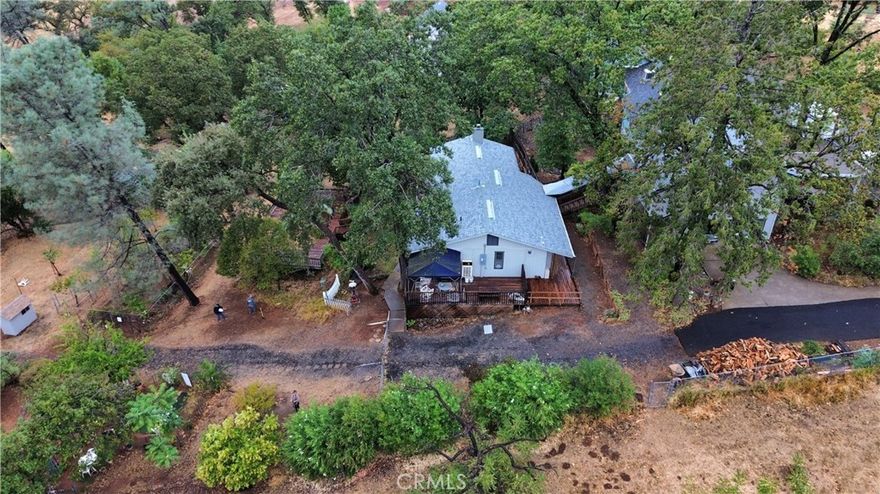 Picture perfect sunsets with a tree house feel! This charming home captures that old saying "Follow me home, I'll show you Paradise!" Plenty of room for all your animals, gardening projects, afternoon BBQing on the deck or just relaxing in the peace & quiet reading your favorite book! With over 2500 sq ft of living space, you'll have room to grow or entertain special guests. Each spacious bedroom has an exit door & also has it's own bathroom. Tucked away on 1.34 acres with the option of purchasing the 1.98 acres next door, you'll have an opportunity to create a one-of-a-kind setting. The welcoming entry leads you to an oversized living room lined with large windows overlooking the property. You'll appreciate the brick hearth with woodstove for keeping cozy & warm during the winter. A step down kitchen and dining area are close by offering plenty of room for preparing to serve & welcome your guests. Just off the dining area is a private office with a half bath. The master bedroom is huge and offers a private balcony & large windows allowing lots of light in and even picturesque views of evening sunsets. As you wind down the staircase to the guest bedrooms, you'll find a large foyer that leads outside to the backyard space. Each bedroom downstairs is spacious and has a private bathroom attached. There is also a large laundry room with storage space. You'll appreciate the finished garage space with room for 2 vehicles. Above the detached garage space, there is an enormous room that could be used as a shop, craft space, storage area, game room, etc. There is so much to offer throughout this entire property, it requires you to see it all in person. Make an appointment today to see this truly unique home & acreage!
