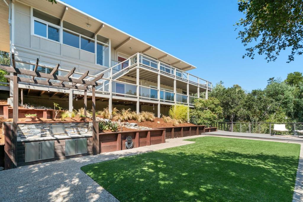 Enjoy stunning views of Monterey Bay and Santa Cruz from this beautiful home. Step onto the large deck and take in sweeping vistas that extend into the kitchen, dining area, and living room by a wall of windows. The updated kitchen features quartz counters, crisp white shaker cabinets, and stainless steel appliances, making it both stylish and functional. Adjacent to the kitchen, a sunroom offers the perfect spot to savor your morning coffee. The dining area flows into the living room, where built-in shelving surrounds a gas fireplace, creating a warm and inviting space. The primary bedroom is a serene retreat with an updated en-suite bathroom featuring quartz counters and a spacious stall shower. Two additional bedrooms share an equally well-appointed hall bathroom. A spiral staircase leads to a versatile lower-level den with a Murphy bed, wet bar, and full bathroom. This space is perfect as a home office, guest suite, or additional living space. For outdoor enthusiasts, the home offers multiple spaces to enjoy the Santa Cruz sun. The upstairs deck, located off the kitchen, is ideal for alfresco dining, while a flat, artificial turf yard below the home provides a space for relaxation and play. Don't miss this opportunity to own a piece of paradise in Santa Cruz. Welcome home!