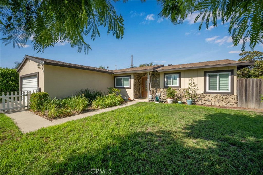 Welcome to this charming home located in Southwest Fullerton on an oversized corner lot with a white picket fence. This 4 bedroom, 2 bath features a freshly painted interior and a nice open floor plan. It offers a galley kitchen with gas stovetop, ample storage, and a bright & airy dining area. The spacious living room with a cozy fireplace makes it ideal for family gathering. Amenities include A/C, ceiling fans, new carpeting, laminate flooring, dual-pane vinyl windows, mirrored closet doors, direct garage access (for laundry) and more. There's a large private back yard with vinyl/wood fencing and plenty of yard space. The home is conveniently located close to schools, The Source OC, amusement parks, and easy freeway access. Lots of potential to add your personal touches and make this special home yours!