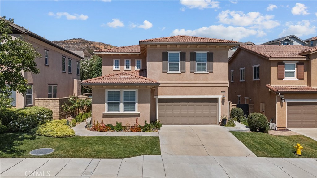 Gorgeous cul-de-sac home in the gated West Hills community in Valencia. This updated 4-bedroom, 3-bath home includes a downstairs bedroom and full bath, perfect for guests. The family room features an oversized ceiling fan with a cozy fireplace, opening to an updated kitchen with quartz countertops, modern backsplash, pendant lighting, an island with seating for three, and a farmhouse sink. Upstairs you'll find a spacious primary suite with double walk-in closets and a large en suite bath, along with two more nicely sized bedrooms and another updated full bath. There's also a large laundry room upstairs with plenty of storage for added convenience. The home has been updated throughout and features many wonderful upgrades; laminate flooring, gorgeous chandeliers, bedrooms have ceiling fans and closet organizers, built-in cabinets in garage for added storage, and zoned HVAC system. The backyard is private, low maintenance, and feels like an extension of the living space, with a full shade cover roof with patio bistro lights and a mounted TV making it a great spot for entertaining. Located near award-winning schools, the West Hills HOA includes pools, spas, a fire pit, outdoor cooking areas, biking trails, clubhouse, security, and walking trails. Close to award winning schools, shopping, restaurants, and parks—this is a great opportunity to live in one of Valencia’s most loved neighborhoods.