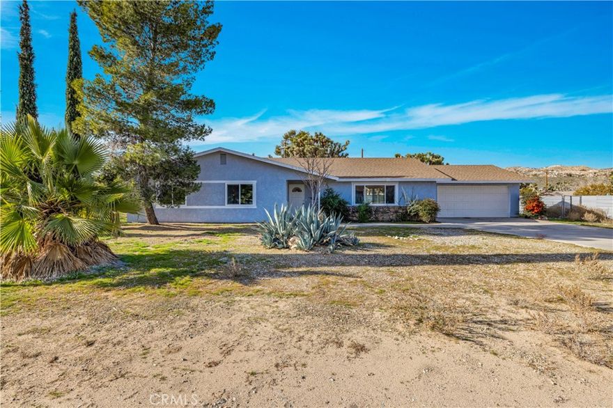 This beautifully remodeled 3-bedroom, 2-bathroom home offers spacious living and stylish updates, all in a highly convenient location just minutes from restaurants, shopping centers, and all that Yucca Valley has to offer. As you approach the property, you’ll love the curb appeal created by the mature trees, a large concrete driveway, and an attached two-car garage. There is also a convenient drive-thru gate leading to the fully fenced backyard—perfect for RVs, trailers, or additional parking. Step inside to find a light, bright, and airy open floor plan with fresh interior paint, new luxury vinyl plank flooring throughout, NEW WINDOWS, and recessed lighting. The large living room and generous dining area provide comfortable and versatile spaces for relaxing and entertaining. The kitchen is completely new, featuring brand-new cabinetry, stunning quartz countertops, stainless steel appliances, and a stainless steel sink. The layout is functional with plenty of storage and counter space to meet your everyday needs. The primary bedroom is spacious and includes two closets—one of which is a walk-in—as well as a fully remodeled ensuite bathroom. The ensuite features modern finishes, a large walk-in tile shower, glass enclosure, rain showerhead with wand, and a stylish dual-sink vanity. The additional two bedrooms are also generously sized and located near the remodeled guest bathroom, which includes a shower-tub combo and upgraded vanity. Additional highlights include an indoor laundry room with added storage, a two-car garage, a large covered back patio, and a flat, usable backyard that’s completely fenced for privacy. Homes of this size and condition in this central location do not last long. Call today to schedule your private showing!