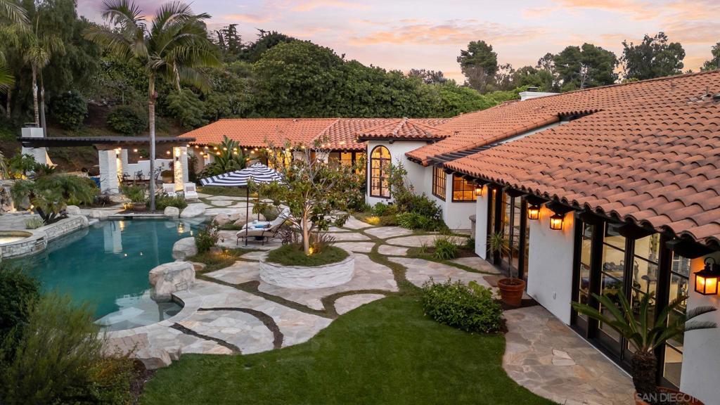 INCREDIBLE single-level estate located in the prestigious Rancho Santa Fe Covenant. Privately gated on 3.39 acres of picturesque land with serene views and unmatched privacy. This light-filled home features Saltillo tile throughout, 4+ bedrooms including a spacious live-in guest suite, and an expansive primary retreat with a reimagined spa-inspired bath complete with soaking tub, custom oversized walk-in steam shower, and private courtyard with hot tub. Additional highlights include a full gym, executive library, dedicated office, and a custom bar perfect for entertaining. The layout flows seamlessly to a resort-style saltwater pool with hot tub, splash pool, cascading waterfall, and a spacious covered patio with built-in BBQ and wood-burning fireplace, the ultimate setting for indoor-outdoor living. Smart home upgrades include built-in speakers, Pentair system, Doorbird, security cameras, EV charger, and fully owned solar with 3 backup batteries for easy living. A generous motor court, 200+ avocado tree grove, and family citrus orchard make this home truly special!