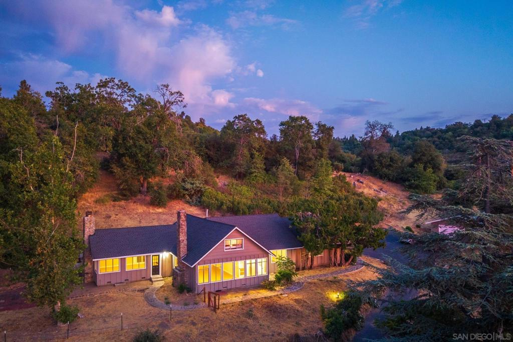 Best value on the market for a home of this size on over 4 acres! Located in the desirable Pine Hills community of Julian, this single-story ranch-style home offers 4 bedrooms, 2 baths, and 2,328 sq. ft. of comfortable living space on 4.28 scenic acres. Inside, you’ll find a generously sized living room and a spacious family room, each featuring its own fireplace or wood-burning stove—perfect for cozy mountain evenings. The home exudes vintage charm and offers plenty of space for a large family to grow, gather, and make it their own. The property includes an oversized 4-car tandem garage, a 4-stall barn with its own separate driveway, and a shared well. Enjoy stunning views of Volcan Mountain and the surrounding hills from multiple outdoor spaces. Just minutes from Main Street Julian, you’ll have easy access to shopping, dining, and year-round events. Don’t miss this rare opportunity to own a spacious home with acreage, mountain views, and endless potential in one of Julian’s most sought-after neighborhoods. Julian is a charming historic town nestled in the Cuyamaca Mountains, about an hour east of San Diego. Known for its small-town charm, gold rush history, and famous apple orchards, Julian is a popular getaway for those looking to enjoy fresh mountain air, scenic landscapes, and a slower pace of life. Real estate in Julian ranges from historic cabins to modern mountain retreats, making it an ideal location for those looking for a peaceful, nature-filled lifestyle with easy access to San Diego and Orange County.