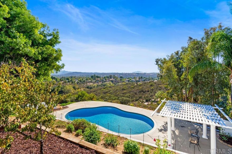 Welcome to this 4-bedroom, 2.5-bathroom, single-level home with a clean contemporary design and offering over 3,000 sq. ft. of living space.  Located in the in the heart of San Diego County, in the highly desired Ramona neighborhood of the San Diego Country Estates.   The kitchen features quartz countertops, stainless steel appliances, a spring water filtration system, as well as plenty of storage and workspace.  The primary suite includes a fireplace, large walk-in closet, jacuzzi soaking tub, and separate shower.   A split bedroom floor plan provides privacy, with three additional bedrooms—all on the opposite wing of the primary suite.  Formal areas of the home include a unique octagonal living space with large windows that fill the home with natural light and a large formal dining room.   The family room features vaulted ceilings and a fireplace, creating a comfortable and open atmosphere.  Step outside to your fully fenced private backyard retreat, complete with a sparkling pool, covered patio, and shaded seating area. The backyard also includes a collection of fruit trees, featuring peach, asian pear, pomegranate, orange and apricot.  Enjoy panoramic views of Eagle Peak, the Laguna Mountains, and Cuyamaca Mountains, often snow-capped in winter. The property backs to open space, offering privacy in a natural setting.  Additional features include a spacious indoor laundry room with deep sink, folding station, and ample storage in the 2-car garage.  If you’re searching for a single-story home for sale in Ramona, CA with mountain views, modern updates, and a pool, this home offers an ideal blend of comfort, space, and setting. Come see what makes this Ramona property stand out!