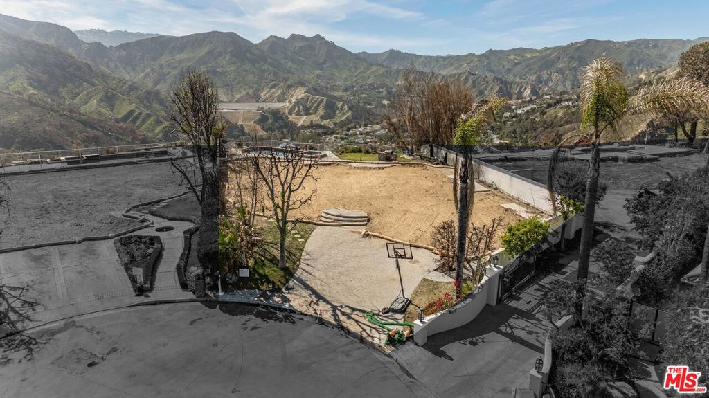 Set on a peaceful cul-de-sac in the exclusive Palisades Highlands, 1117 Cumbre Alta Court presents a rare opportunity to craft a bespoke estate in one of Los Angeles' most serene and scenic enclaves. Encompassing 15,347 square feet (.35 acres) of bluff-front land, this premier homesite offers a commanding vantage point to take in panoramic mountain and canyon vistas, along with pee-a-boo ocean views. This prestigious parcel is offered with completed environmental remediation, eliminating a major step and providing a smooth path toward development. Included in the sale are architectural plans by Bob Drueco AIA & Associates, originally created in 1988 for a stately 6,905-square-foot English Tudor residence with 6-bedrooms, 7-bathrooms, and a generous 912-square-foot three-car garage. The former residence boasted a double-height foyer with a sweeping curved staircase, formal and informal living spaces, a gourmet kitchen with breakfast area, dedicated office, a main level guest suite, and multiple gathering areas ideal for refined entertaining. The upper level included a spacious primary suite with luxe ensuite bath, dual walk-in closets, and a private covered balcony, alongside three additional guest suites, and a versatile recreation room. With dramatic views from both levels, the layout seamlessly connected indoor luxury with the breathtaking natural surroundings. Whether you choose to revive the original vision or reimagine a modern masterpiece, 1117 Cumbre Alta Court offers a chance to build your dream home in a neighborhood prized for its privacy, prestige, and proximity to the beaches, Palisades Village, and the best of the Westside via Palisades Drive and Sunset Boulevard.
