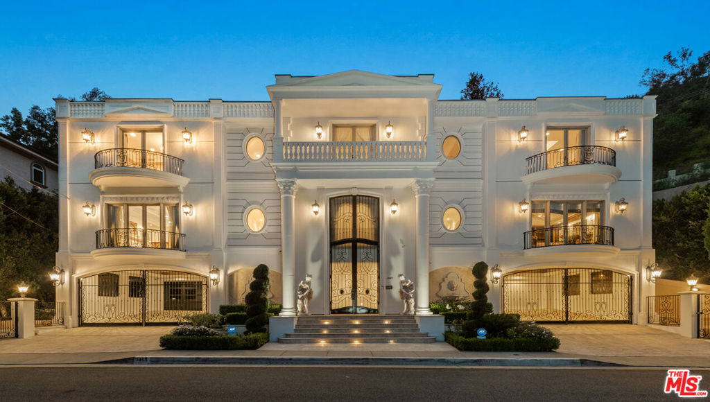 Welcome to a world of timeless grandeur and refined elegance in this spectacular French Colonial estate, originally envisioned to host diplomats and royalty with the utmost discretion and comfort. Nestled on prestigious Robmar Drive, just moments from the pulse of Beverly Hills and iconic Rodeo Drive, this palatial residence offers an unmatched lifestyle of luxury and sophistication. With 5 bedrooms and 8 bathrooms, the home welcomes you with a dramatic double-height foyer, where sweeping twin staircases with ornate wrought-iron railings ascend beneath a magnificent chandelier. The main level is anchored by a lavish great room perfect for entertaining on any scale. The gourmet kitchen is a chef's dream, complete with sculpted marble countertops and a charming breakfast nook. Adjacent, the formal dining room is accented by a hand carved marble fireplace, while the family room offers a warm ambiance with a custom hardwood entertainment center and additional fireplace. The stately library impresses with a richly detailed coffered ceiling, fireplace, and custom-built bookshelves and cabinetry. Upstairs, the expansive primary suite is a true sanctuary, boasting both a luxurious sleeping chamber and an elegant sitting room each with its own fireplace. The oversized walk-in closet features custom hardwood cabinetry and a central island, while the spa-like primary bathroom includes dual vanities, dual showers, a soaking tub, and exquisite inlaid marble flooring. Three additional en suite guest bedrooms offer comfort and privacy for family and visitors alike. Thoughtfully designed for both beauty and functionality, the home is served by an elevator and adorned with polished marble and inlaid hardwood flooring, hand-painted ceilings, charming chandeliers, French doors, balconies, and opulent window treatments throughout. Outdoors, a serene private patio leads to a lush lawn, sparkling pool, and relaxing spa, all set against a terraced hillside of mature landscaping with fruit trees. The lower level completes the estate with a state-of-the-art gym, a professional-grade screening room, and a crescent-shaped, dual-gated motor court for secure, stylish arrivals. Meticulously maintained, this architectural masterpiece is a rare offering providing privacy, prestige, and proximity to the best shopping, dining, and entertainment in the world-renowned city of Beverly Hills.