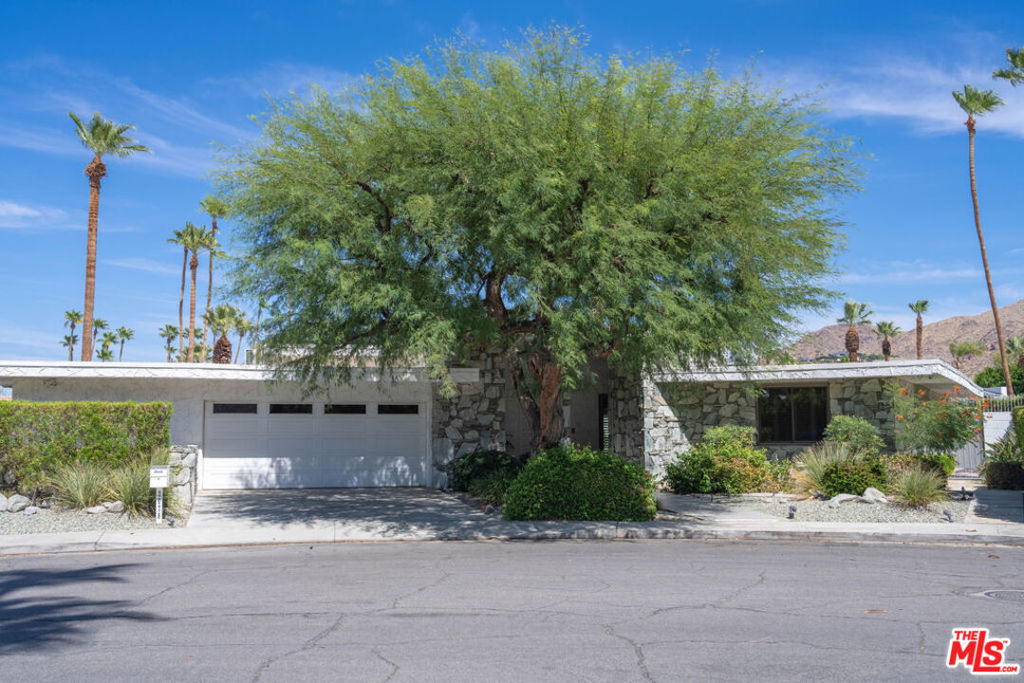 Welcome to your ultimate desert sanctuary in the prestigious Indian Canyon neighborhood of South Palm Springs. This exquisite home offers over 3,500 square feet of elegant living space on a generous 10,890 square foot fee-simple lot meaning you own the land outright with no HOA restrictions. Designed with both comfort and effortless entertaining in mind, the residence features three spacious bedrooms, three and a half bathrooms, plus a versatile bonus room perfect for a home office, den, or even a fourth bedroom. The sun-filled great room impresses with soaring ceilings, clerestory windows framing stunning mountain views, and a built-in wet bar ideal for entertaining guests or enjoying cozy nights in. The chef's kitchen boasts sleek cabinetry, abundant storage, and a bright breakfast nook overlooking the lush, private backyard. Your primary suite is a true retreat, complete with direct patio and pool access, dual vanities, and generous closet space. Two additional bedrooms offer privacy and comfort, while the flexible bonus room expands your living possibilities. Step outside to your own desert oasis featuring a sparkling pool and spa, mature landscaping, and multiple lounge areas designed for relaxation and entertaining under the open sky. This home offers wonderful potential to enhance and customize its exceptional features, allowing you to create a truly personalized desert retreat. Additional highlights include energy-efficient dual-pane windows and sliders, solar panels, dual HVAC systems, and a spacious two-car garage with ample storage. Whether you're seeking a stunning primary residence, a luxurious second home, or a high-performing rental, this property offers endless potential to bring your desert dreams to life. Conveniently located near world-class dining, golf, shopping, and entertainment, this is your opportunity to own a true Palm Springs gem.