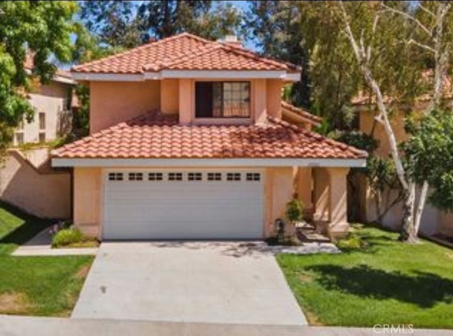 Nestled on a quiet residential street within one of Santa Clarita’s charming neighborhoods lies this beautifully maintained 1,911 sq ft residence, offering 4 bedrooms and 2.5 bathrooms—move-in ready for its fortunate new owner. A paved driveway bordered by a well-groomed lawn leads to the inviting entrance. Inside, you're greeted by warm chestnut-hued laminate floors, soaring ceilings, and an airy open-concept design.
The spacious family room showcases light-blonde laminate flooring and seamlessly flows into the kitchen, which features a central island, crisp white cabinetry, tiled countertops, and integrated appliances. The smooth connectivity between the living spaces creates an ideal atmosphere for gatherings and entertaining. Sliding doors from the living area open to a private backyard retreat, complete with a covered patio—perfect for outdoor seating. Steps from the patio lead to an upper-level deck for added relaxation or entertaining space.
Upstairs, a long hallway connects three carpeted bedrooms, each with built-in closets, and a shared full bathroom. At the opposite end, the primary suite boasts an en-suite bathroom, dual walk-in closets, and direct access to the upper patio/deck.
Additional highlights include direct entry to an attached two-car garage—offering flexible space for a workshop—and dedicated washer/dryer hookups.
