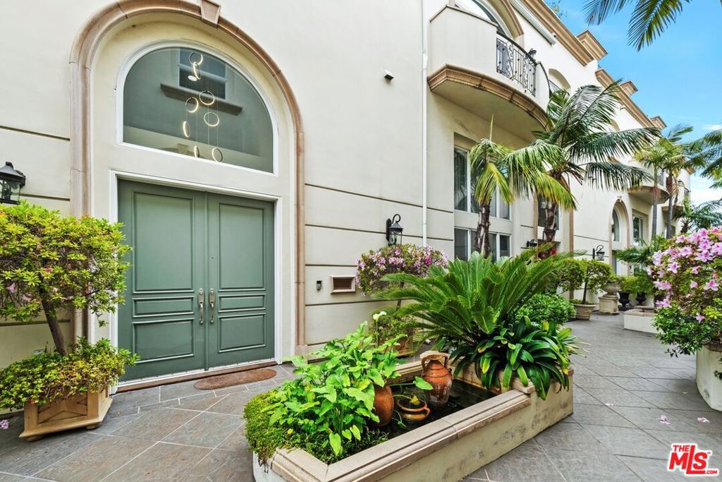 PREMIER FRONT-FACING CORNER RESIDENCE IN BRENTWOOD'S MAYFIELD GARDENS. Discover Brentwood living at its best in Mayfield Gardens, an intimate Mediterranean-inspired community of just eight homes behind a private gated entry. This rare, front-facing corner townhome is the largest and best unit in the complex, offering expansive interiors and abundant natural light throughout the day. Enter through a lush courtyard with mature landscaping and a tranquil fountain that sets the tone for refined living. Inside, soaring ceilings, polished marble floors, and a grand fireplace anchor the formal living room, which flows seamlessly into a dining area ideal for entertaining or relaxed evenings. The chef's kitchen boasts Viking and Sub-Zero appliances, marble countertops, and a large center island designed for both everyday meals and gatherings. A dedicated office with custom built-ins adds versatility, also suitable as a den, library or media room. Upstairs, the primary suite is a private retreat with a walk-in closet, dressing area, and spa-style bath with soaking tub, oversized shower, and dual vanities. Three additional en-suite bedrooms provide flexibility for family, guests, or creative space. A private rooftop deck crowns the home with sweeping city and mountain views, ideal for morning coffee, sunset gatherings, or weekend barbecues. Direct entry from a private two-car garage and an in-unit elevator ensure ease and convenience across all levels. Perfectly positioned between Montana Avenue and Wilshire Boulevard, this light-filled Brentwood residence is moments from boutiques, cafes, and the iconic Country Mart. This is a rare chance to own the largest, most desirable residence in a highly sought-after gated community. Schedule your private showing today.