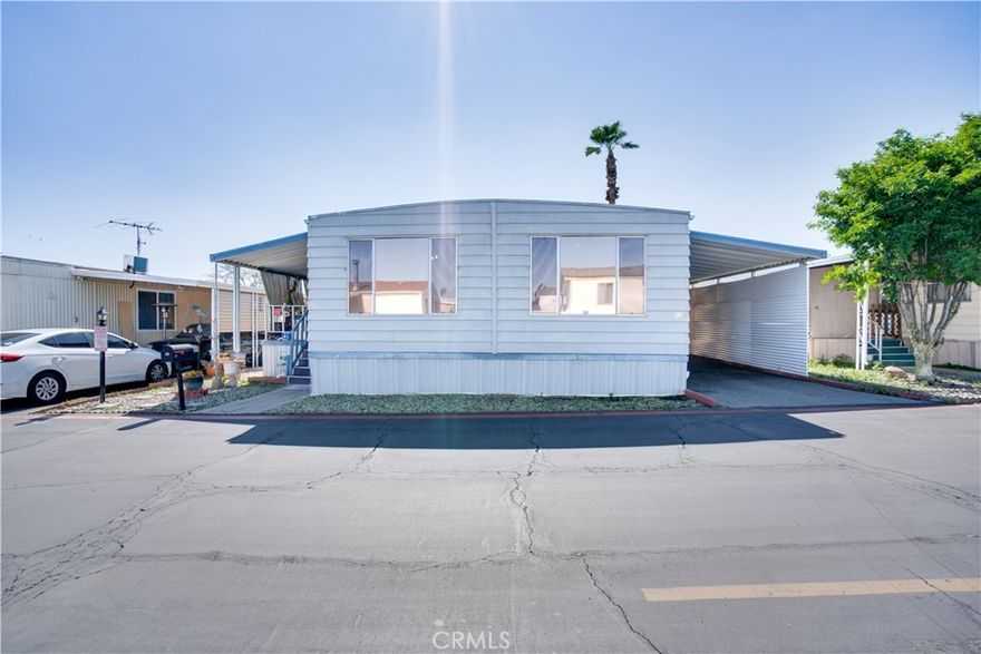 Welcome to this beautifully maintained double-wide mobile home located in the desirable Country Squire Mobile Estates! This spacious home features 3 bedrooms and 2 full bathrooms, including a generous primary suite with a large walk-in closet and a private bathroom equipped with double sinks. Enjoy an open-concept living room that flows seamlessly into an inviting kitchen—perfect for both everyday living and entertaining. The covered front porch offers a great space to relax outdoors, while the spacious carport provides convenient parking and additional storage. Ideally situated close to shopping centers, schools, and other local amenities, this home offers comfort, convenience, and affordability in a well-established community.