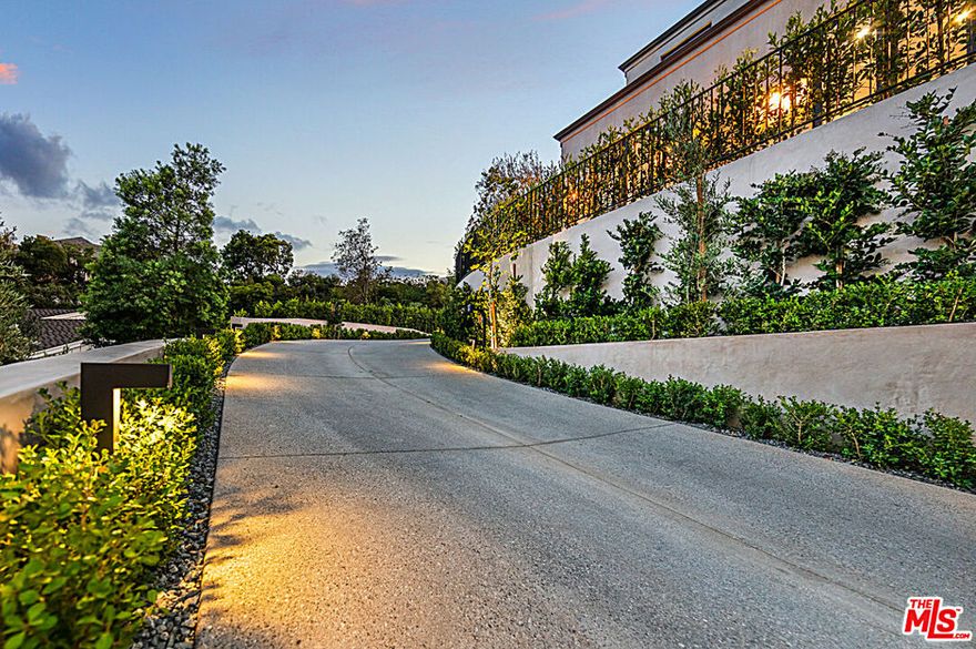 Moments from the Beverly Hills Hotel and Sunset Blvd, this new construction architectural triumph built by renowned developer Holland Ashrafnia, is the quintessential home for Southern California lifestyle. Meticulously designed by the Harrison Design Group and Colab House, this home rich in privacy perched above the street behind sound gates offers epic scale, cutting-edge smart home technology, and seamless indoor-outdoor flow. French steel doors transcend into a voluminous foyer connecting all common rooms with little resistance. This open floor plan with soaring ceilings feels airy, yet warm due to the home's immaculate woodworking made from organic rift white oak. An effortless transition from the state-of-the-art kitchen, butlers pantry and formal dining room, invites an intimate yet ceremonial dining experience for all. The master suite offers views, a spectacular bath with dual vanities, his and hers closets, and a romantic private balcony. The one of a kind lower-level presents a gym, sauna, wine cellar, two en-suite bedrooms, and a home theatre with a bar. An estate designed for large-scale entertaining, walls of disappearing glass doors grant a spacious patio connected to a cozy and elegant terrace with an outdoor kitchen. Create memories gathering around a modern fire pit centered on a wooden deck, while enjoying the mesmerizing zero edge infinity pool above the spacious lawn. This coveted backyard sits beautifully landscaped and lined with multi-tiered blooming olive groves, creating your own private oasis. The H Group spared no expense developing this one of a kind masterpiece.