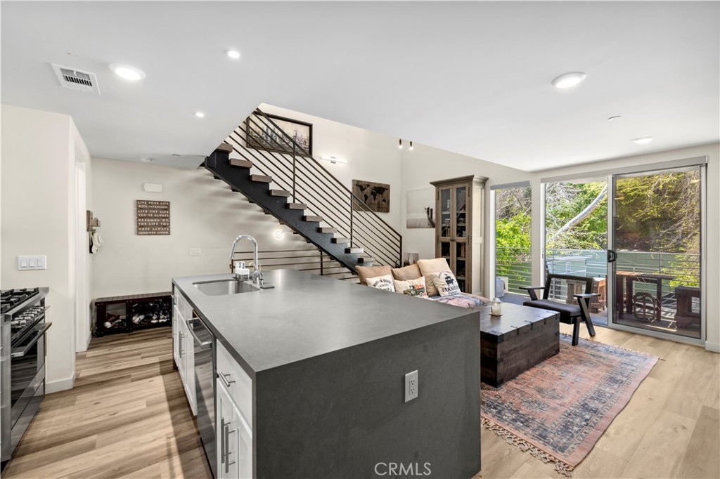 Exceptionally rare, undeniably luxurious, and one of the only newer-construction residences of its kind in Laguna Beach, this modern, open and light-filled condo offers a versatile live/work design at The Sheds in the heart of Laguna Canyon. Artists, including fashion, graphic and web designers, urban planners, architects and more, will find the space to be an ideal environment for creativity. The talents of Laguna Beach-based Horst Architects, Inc. are on display throughout the three-level loft-style floorplan, which includes two covered parking spaces on the first floor, main living areas on the second, and an office with sunny balcony on the third. Enjoy two ensuite bedrooms with walk-in closets, two baths, and a spacious living room with private deck. Opening directly to the family room, the high-end kitchen features a large dual-waterfall island with bar seating, quartz countertops, white Shaker cabinetry, a farmhouse sink and top-tier stainless steel appliances. Floating staircases, vaulted ceilings, hardwood flooring, large windows and glass doors, and high-end finishes and fixtures place this live/work condo and its three neighbors at The Sheds in a league of their own. Views of Laguna Canyon’s natural beauty are enjoyed from every floor, and its location places residents within minutes of the Laguna College of Art and Design, Laguna’s postcard-perfect beaches, hiking and biking trails, and village galleries, cafés, restaurants, clubs and shops.