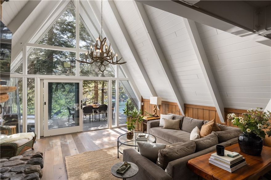 Discover this beautifully remodeled lakefront retreat tucked away on one of Lake Arrowhead’s most sought-after streets. With sparkling lake views, designer finishes, and a private single-slip dock (Dock #S26), this 3,720 sq ft home offers the perfect blend of modern luxury and mountain charm. Step inside to a bright, open-concept double A-Frame with expansive windows and fluid outdoor spaces. The main-level great room centers around a dramatic stone fireplace with the lake as the backdrop and sliding doors opening onto an entertainer’s deck overlooking the water. The gourmet kitchen features high-end appliances, a large island, built-in dinning banquette and adjacent BBQ patio—ideal for hosting gatherings year-round.

The spacious main-floor primary suite boasts serene lake views and a spa-inspired en-suite bath with a floating tub with views of the water. Upstairs, two guest bedrooms, each with a-frame architecture, share an interior water-view balcony, while the lower level includes a fourth bedroom, full bath, laundry room, and an incredible media/game room with surround sound and built-in bar—perfect for cozy nights or lively weekends.

Enjoy multiple decks, a covered patio with a hot tub, and direct access to Lake Arrowhead’s clear waters. The property includes off-street parking for four vehicles, dual Tesla charging stations, a whole-house generator, central air conditioning and a security camera system for ultimate comfort and peace of mind.

Located just minutes from Lake Arrowhead Village and year-round recreational opportunities, 161 Rocky Point Rd is your private escape—whether as a full-time residence, weekend getaway, or luxury rental.