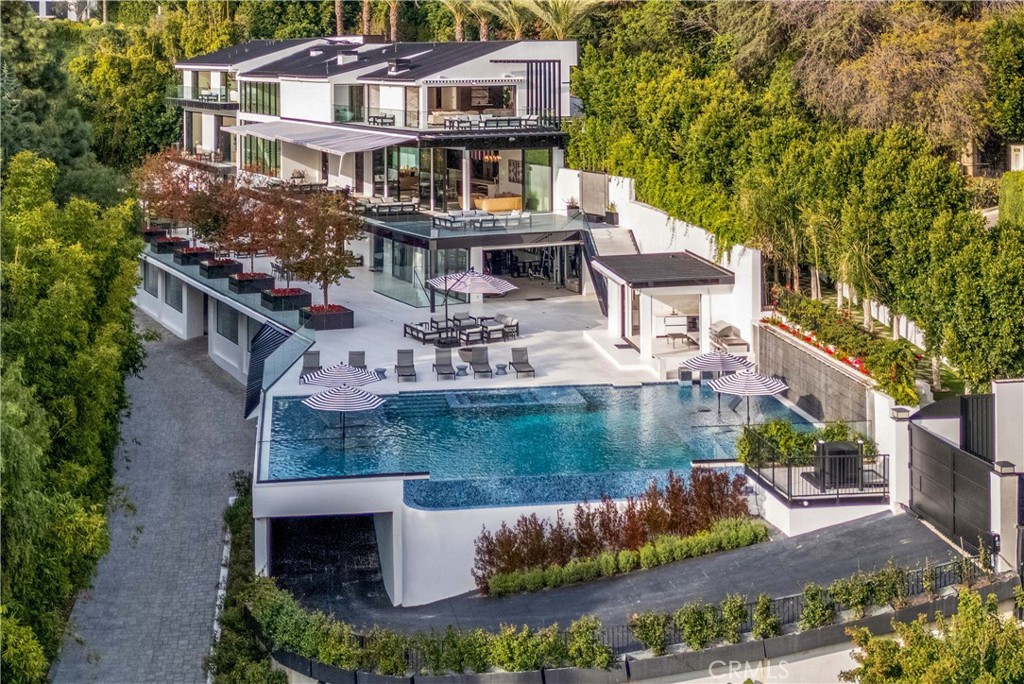 Nestled in the ultra-exclusive "Billionaire's Row" of lower Bel Air, this spectacular, newly constructed estate represents the pinnacle of luxury living and entertaining. This sleek modern oasis offers an unparalleled layout, breathtaking panoramic city views, and every conceivable amenity, all secured within a private and gated setting surrounded by some of the world's most valuable real estate. This magnificent estate is designed for grand-scale entertaining and luxurious daily living. The primary suite is a sanctuary of luxury, offering a grand marble fireplace, a wraparound deck, two oversized rainwater showers, a Zen soaking tub, and custom walk-in closets. In addition, there are five other bedrooms, each with their own ensuite bathrooms and walk in closets. Other features of this one of a kind residence include a grand ballroom, multiple dens and lounges, and a luxurious media room with 4K D-ILA precision projector. For leisure and wellness, the residence boasts a state-of-the-art gym equipped with premium Matrix and Hoist machines, a lavish spa with a sauna, and an almost Olympic size swimming pool that affords captivating city views and rivals the most opulent Las Vegas Hotels. Automated Fleetwood floor-to-ceiling doors seamlessly blend the indoor and outdoor living areas. This magnificent property feels like a 7-star hotel and is equipped with multiple kitchens to cater to any occasion, including a separate chef's preparatory kitchen that’s tucked away. These spaces are outfitted with top-tier Miele and Wolf appliances and feature sculpted marble islands. A truly unique feature of the property is its massive subterranean garage, which can accommodate over 50 vehicles, a rarity in Bel-Air. The estate sits on a lot with 320 feet of frontage on Nimes Road and is protected by 8-foot privacy walls and comprehensive security system, offering exceptional exclusivity and peace of mind. The residence also features an oversized commercial Otis elevator, luxurious heated TOTO toilets in every bathroom, and a self-playing Mason & Hamlin piano, adding a touch of whimsical elegance to the formal ballroom. The residence is also a fully realized smart home with advanced automation, providing ease of function. This trophy estate is more than a home; it is a statement of achievement and a private sanctuary designed for those who demand the very best.