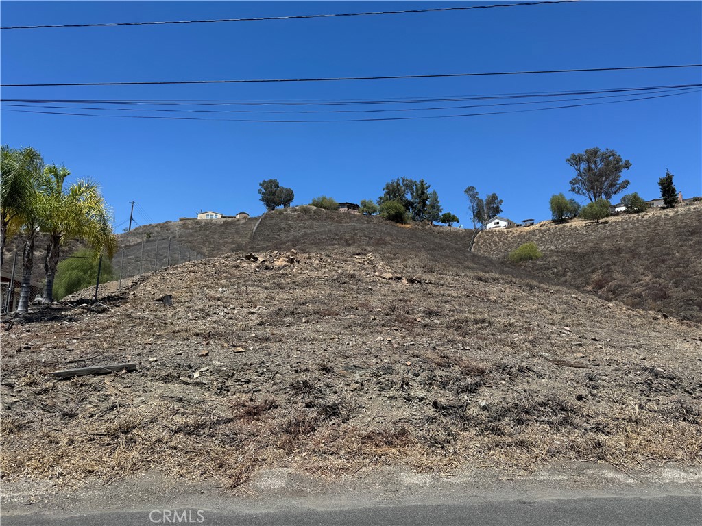 Check out this beautiful 1.22 acre view lot on a paved road with utilities in the street overlooking western Menifee, Audie Murphy Ranch and Canyon Lake! Located just minutes from shopping and freeways, this gentle slopping parcel faces south and features very lovely views of the surrounding communities, foothills and mountains. Power crosses the front of the property and district water is available in Beverly Road. It is unknown if sewer is available nearby. The slope levels out a bit near the midpoint of the property on the western side which should make for a very nice pad location for your custom home. Property has chain link fencing already on the northern and western property lines. The parcel the east appears to have been survey'd recently so you can easily identify the property corners from the street. Contact listing agent with any questions. PROPERTY IS LOCATED TO THE RIGHT OF THE HOUSE AT 24180 BEVERLY.