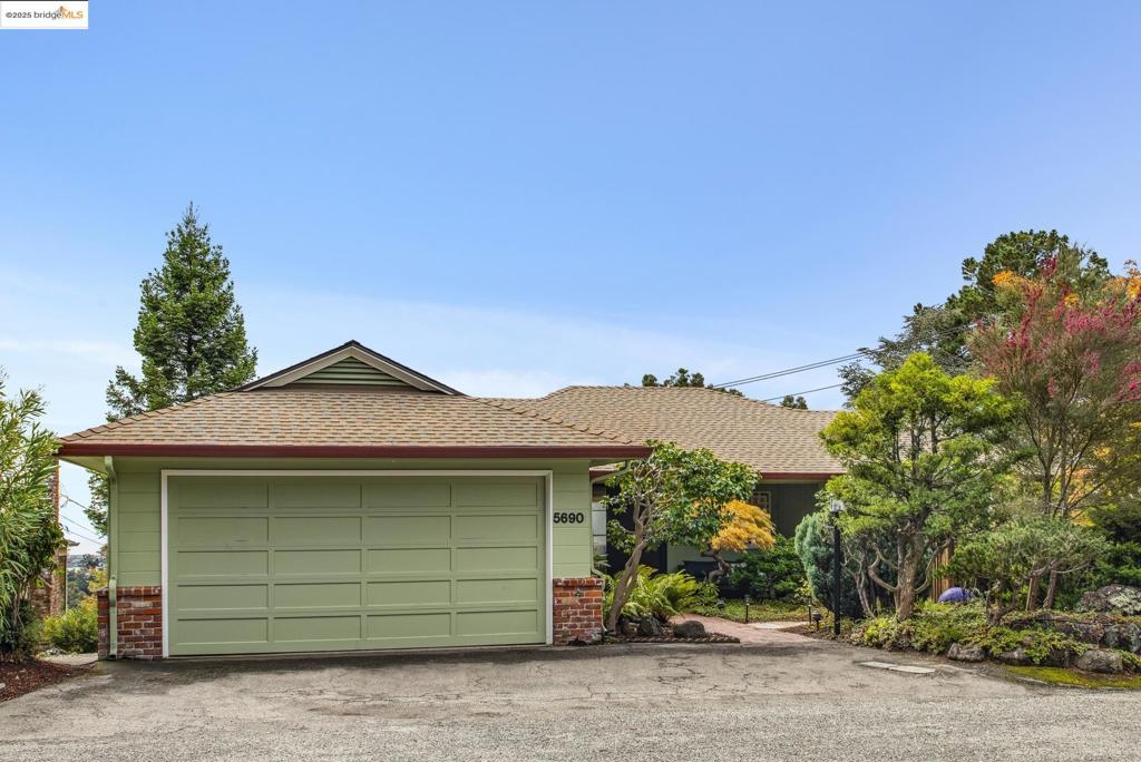 Montclair Hills Living at its Best! This charming 1950s ranch-style home, nestled on a quiet cul-de-sac, offers a peaceful retreat with stunning views of San Francisco and the Bay. Its spacious, well-designed layout includes 3+ bedrooms, 3 baths and 2,179 SF. Inside, the expansive living and dining room features custom built-ins and a striking wood-burning fireplace, with large windows framing picturesque Bay views. The updated eat-in kitchen provides a delightful space for culinary endeavors and seamlessly flows onto the level patio - ideal for outdoor dining and entertaining amid mature gardens. The main level hosts a primary suite, spacious second bedroom, a full hall bath, and an office that doubles as a bedroom. The versatile lower level serves as a family room, extra bedroom, or home office, complete with a full bath and both interior and exterior access, perfect for guests or a media room. Set on a 5,949 SF lot, the beautifully landscaped gardens with redwoods and fruit trees create a lush outdoor oasis. This home also includes interior access to a two-car garage, a dedicated laundry room, and a newer roof. Enjoy proximity to Montclair Village, transit, and freeways, all while basking in the serene hills location. Don't miss this opportunity for tranquil, modern living!
