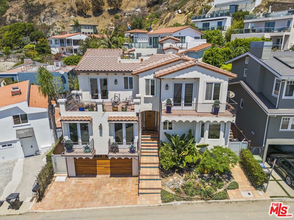 Welcome to 17711 Revello Drive; an incredible opportunity to own a move-in ready piece of the Palisades perched in one of the most coveted seaside enclaves! Completely rebuilt in 2007, this beautifully-maintained residence offers 4 bedrooms, 5 bathrooms, and 3,383 square feet of light-filled living space designed for both comfort and sophistication. Stepping inside, you'll experience the perfect combination of timeless charm and modern upgrades. The floorplan flows seamlessly between multiple living spaces, dining spaces, and an eat-in chef's kitchen equipped with a high-end stainless steel appliance package: a brand new Sub Zero refrigerator, Bosch dishwasher, and Wolf professional range and double oven. Indoor spaces flow seamlessly to two expansive decks where ocean breezes and sunset vistas create the perfect backdrop for morning coffee or evening gatherings. The primary suite is your own private retreat within the home, offering two expansive closet spaces, an en-suite bath with ocean views, and a dual sink vanity and a walk-in shower. The three additional bedrooms are generously sized, and the four bathrooms have been meticulously maintained. Outside, a beautifully hardscaped Moroccan-inspired garden offers a private sanctuary with its own fireplace and built-in BBQ- an entertainer's dream. The home's enviable location is just steps from a public staircase leading directly to the beach, making spontaneous seaside walks a daily pleasure. Additional features include two inviting gas fireplaces, a dedicated wine storage room with its own refrigerated AC system, a tankless water heater for endless hot water, and a Tesla charging station for effortless EV living. A chair lift is currently installed for ease of movement, though it can be removed at the buyer's request. Every element of this property is designed to enhance the coastal lifestyle, from its serene indoor comforts to its inviting outdoor escapes. Whether envisioned as a tranquil retreat or a vibrant gathering place, this property offers the perfect blend of elegance, functionality, and proximity to the Pacific Ocean. Welcome home!