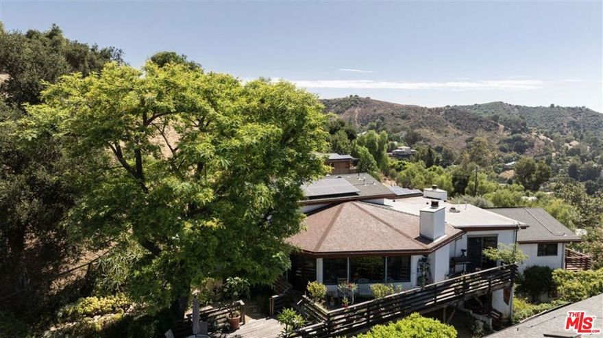 HUGE PRICE REDUCTION. $200,000 price reduction since listed. The most sq footage for the money in Topanga. Nine out of eleven rooms have views. Calling all stargazers and full moon aficionados.  This home is far from the madding crowd yet minutes to Calabasas. Enjoy sunrise-to-sunset canyon vistas. The spacious living room with dramatic ceilings, commanding mountain views and fireplace soaks in the awe.  2 story ceilings in the den has its own fireplace,  and a convenient powder room that makes a perfect entertainment zone. The formal dining area seats 10 and is steps from the chef's kitchen. Custom birch cabinetry, granite countertops, and top-of-the-line appliances, a Thermador six-burner range, wood-clad Sub-Zero fridge and informal eat-in area.  An office with a private entrance is ideal for people who work from home. The primary bedroom includes a private deck, walk-in closet and an ensuite bath with separate shower and tub . The two additional bedrooms share a full bath and both have their own outdoor seating areas. A two-car attached garage, plenty of storage, and a 4.32 kW Tesla solar system, this home is an ideal blend of comfort and style. Minutes from Calabasas and Topanga Beach.