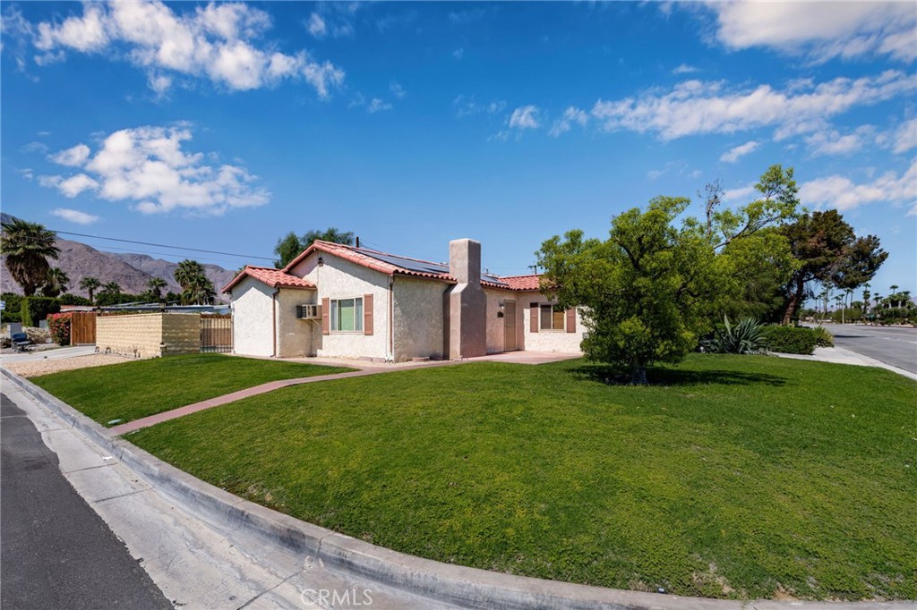 Timeless Spanish cottage in one of the BEST NEIGHBORHOODS in Palm Springs - Movie Colony East! Sited on a highly coveted corner lot ... this charmer not only provides majestic views of our towering mountains as your personal backdrop but also abundant parking with easy navigation. A highly flexible exterior design affords for diverse landscape options - including a manicured front lawn, additional parking off N Sunrise, street parking off E Granvia Valmonte (easy to come & go) and a large driveway that can easily accommodate several vehicles or any RV/BOAT needs. An inviting interior space is highlighted by an updated gourmet kitchen with custom cabinetry, stone counters and stainless steel appliances. The kitchen is not only spacious but perfect for entertaining - with direct access to the backyard/dining room and a full size washer & dryer enclosure for easy washing after pool use. Archways provide seamless transitions throughout the home which is anchored by cohesive flooring - with both tile and hardwood providing easy maintenance. A contemporary fireplace accents the main living space and DUAL PANE windows help ensure energy efficiency + reduce exterior noise levels. The main hall bathroom has been expertly updated with a modern design and both bedrooms are well sized. When you have a POOL HOME ... you want to be able to maximize pool time for both you and your guests - we have you covered! The current exterior flex space has the ability to function as a garage, workshop, outdoor kitchen or would make a great ADU project! With the potential to expand based on your needs (and city permitting) ... the home's corner allocation lends itself well to an interior or exterior redesign that could increase interior square footage, a large garage or provide ADU capabilities. One thing's for certain - you want to be in this neighborhood! With nearby homes routinely selling for 1M or more - this neighborhood will support your home project(s) ROI. With only a 2 minute drive to Ruth Hardy Park & a 4 minute drive to downtown, you're in prime position to fully immerse yourself in the Palm Springs outdoor lifestyle that includes a premiere arts, culture & architecture scene. Make this home yours ... schedule a viewing today!