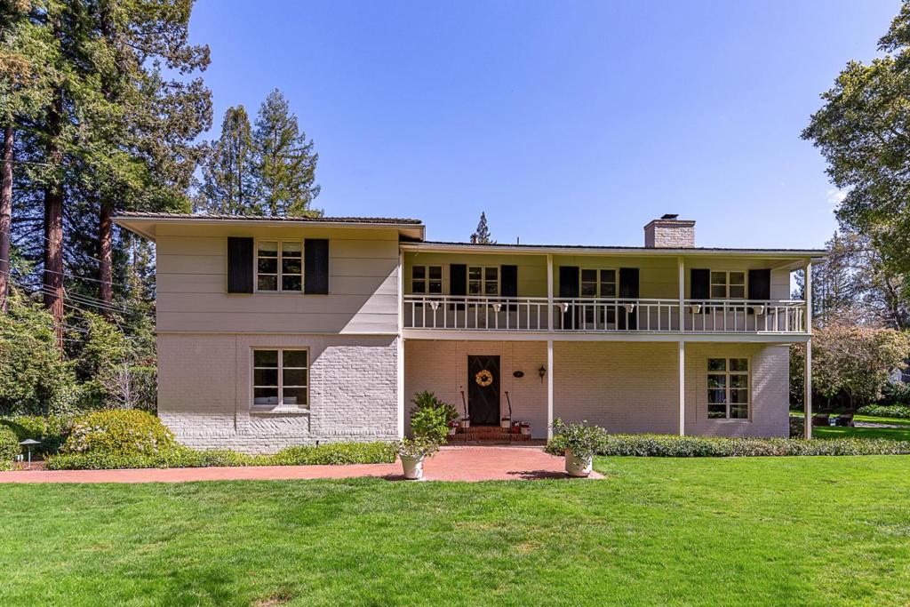 This stately Monterey Colonial home, circa 1935, showcases timeless architectural details of the era on a private, nearly one-acre lot where majestic redwood trees frame the serene setting. Originally designed by renowned architect Gardner Dailey and with landscaping by Thomas Church & Jack Stafford, the property offers abundant potential. Options include moving in and enjoying the enchanting vintage character today, renovating to suit personal tastes, or exploring opportunities to build new. Interior features showcase hardwood floors & crown moldings in some rooms, towering windows & French doors that bathe the interiors in natural light. Formal living & dining rooms, vintage bar area, bright kitchen with casual dining area, & a flexible room with en suite bath ideal for a family room/bedroom. Grounds are equally inviting, featuring a sparkling pool, expansive covered & open patios perfect for entertaining, & lush lawn areas with raised vegetable beds. Two-car garage with adjoining workshop & laundry area, plus a carport & partial basement are also featured. With its blend of privacy, charm, and opportunity, this home offers a rare combination in a highly desirable location.