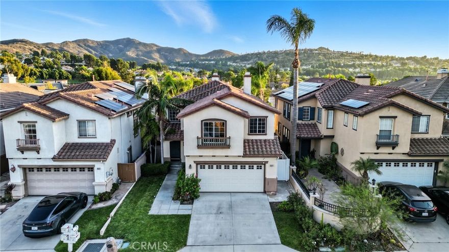 Welcome to 8674 E Sunnywalk Lane, a stunning 4-bedroom, 2.5-bath home located in one of the most desirable Anaheim Hills neighborhoods. This residence offers a bright and open floor plan with high ceilings and abundant natural light throughout. The downstairs layout features a seamless flow between the living room, family room, dining area, and kitchen — perfect for both relaxing and entertaining. The modern kitchen is beautifully upgraded with white cabinets, quartz countertops, and stainless steel appliances. A bedroom and laundry room are conveniently located downstairs next to the attached 2-car garage. Upstairs includes a spacious loft ideal for a home office or media space, along with generously sized bedrooms and a large master suite with ample closet space. Step outside to enjoy the spacious backyard with panoramic views — this is a premium view lot that provides the perfect setting for outdoor gatherings or quiet evenings. The home features LVP flooring throughout and a clean, contemporary feel in every room. Ideally located within walking distance to the award-winning Running Springs Elementary School and Ronald Reagan Park, this home offers both comfort and convenience in a highly sought-after community.
