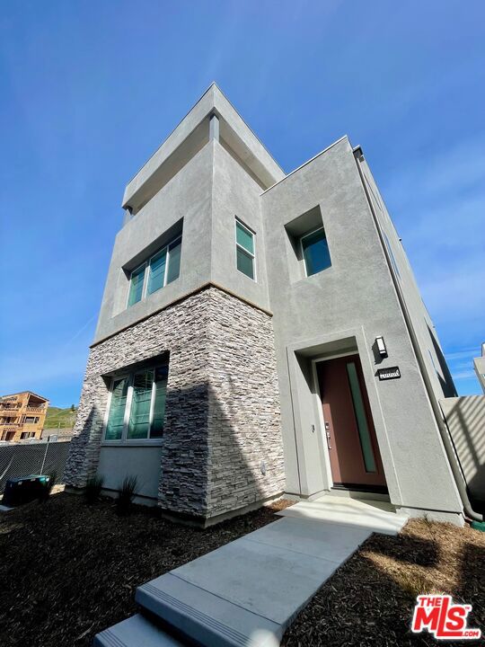 Gorgeous home is move-in ready WITH EV CHARGER IN THE GARAGE & ENERGY SAVING SOLAR PANELS! Enjoy this south facing, bright and airy 4 bed, 4.5 bath multi-level home featuring a welcoming 2 story foyer, flows to 10-foot ceilings great room with large windows, beautiful wood floors throughout, and spacious 2 1/2 car garage. Open kitchen with huge island & quartz countertops, equipped with stainless steel appliances, soft-close drawers. The first level showcases a spacious open floorplan, shared between the Great Room, kitchen and dining room. Stackable sliding glass doors lead to the California Room for effortless indoor-outdoor living and entertaining. A secondary bedroom on the main floor is situated at the back of the home along with a full bath and a large walk-in pantry. Three more bedrooms can be found on the second floor, including the luxe owner's suite. Master suite includes dual sink vanity, a large walk-in shower, a separate tub, and a spacious walk-in closet, while the other two bedrooms include its own private full bath, convenient 2nd floor laundry, lots of cabinetry for storage and kid's study area in the hallway. A versatile bonus room occupies the top level, with an adjacent covered deck which provides an ideal spot for relaxing, entertainment and enjoying the neighborhood's charm and views. Plus, its great location puts you within reach of everything you need, from shopping and dining options to parks and great schools. Just minutes away from the 5 fwy for easy commuting. Electric vehicle charger installed in the garage. Solar panels also included and already installed on the home to your benefit. Don't miss the chance to make this house your dream home!