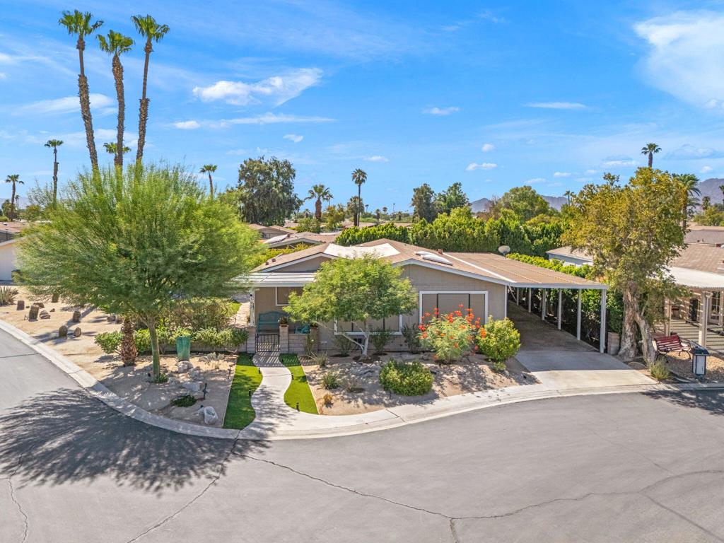 Charming Cottage-Style Home and Exceptional Private Yard in Suncrest Country Club. Known in the community for its beautifully landscaped front yard and welcoming curb appeal, this charming 2-bedroom, 2-bath cottage-style home is a rare find, on a corner lot, situated in the heart of Palm Desert. This hidden gem is a 55+ rent-controlled, gated community that offers great outdoor living.Enjoy the seamless transition from outdoor to indoor spaces as your guests join you on the welcoming front patio for a leisurely coffee and brioche to start the day. Here, the backyard envelops you with the feel of a private oasis, where a flagstone hardscape path, Blue Ranger hedges, and an olive tree transport you to a setting reminiscent of Florence, Italy. In this yard, there is ample space for dining, lounging, gardening, or simply enjoying a vibrant, colorful desert sunset. The pathway takes you to the back of the yard where you find the covered patio near a lovely Acacia tree and garden --perfect for entertaining a small group or a crowd.Inside this lovely 1,584 sq ft home, you find an open layout, with a freshly painted interior, a remodeled primary bathroom, and a well-appointed kitchen equipped with newer appliances, including a professional-grade 5-burner Wolf stove-top. A separate laundry room includes new cabinetry for added storage and functionality. There is an office that overlooks the back covered patio and garden. Newly added west-facing solar screens help maintain a comfortable indoor climate. And, a recently added UV air filtration system helps keep the air clean inside. Suncrest Country Club offers resort-style amenities: multiple pools and spas, a 9-hole regulation golf course, tennis and pickle ball courts, and a clubhouse with a bar, restaurant, and social activities. Located just a short drive from El Paseo's world-class shopping and dining, and centrally located in the Coachella Valley, this is the ideal home for enjoying the best of desert living.
