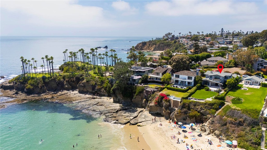 Step inside this stunning coastal home and be immediately captivated by some of the most breathtaking ocean views in all of North Laguna. Wide French doors open to a beautifully designed, three-level outdoor space featuring a wood deck, brick and stone walkway steps that lead you down to the beach, and a spacious grassy area—perfect for both relaxing and entertaining.
Inside, original wood floors create a warm and inviting atmosphere from the main entry through to the formal living room. Unique stone accents enhance built-in bookshelves and a stately mantle that frames the wood-burning fireplace, while timeless wood moldings and decorative finials add charm and character. Expansive windows and additional French doors continue to showcase the remarkable ocean views.
The main level also features a well-appointed kitchen that flows into a functional mudroom with storage, a desk nook, a quaint powder room, and the first of four generously sized bedrooms.
Upstairs, a vintage stained-glass skylight brightens the way to three additional bedrooms, each offering ample closet space and more awe-inspiring views. A full bath serves the upper level, while the primary suite offers built-in cabinets, bookshelves, and a raised sitting area perfectly positioned to take in another stunning angle of the coastline.
This is a truly special opportunity to own a timeless oceanfront home in one of Laguna Beach’s most sought-after neighborhoods.