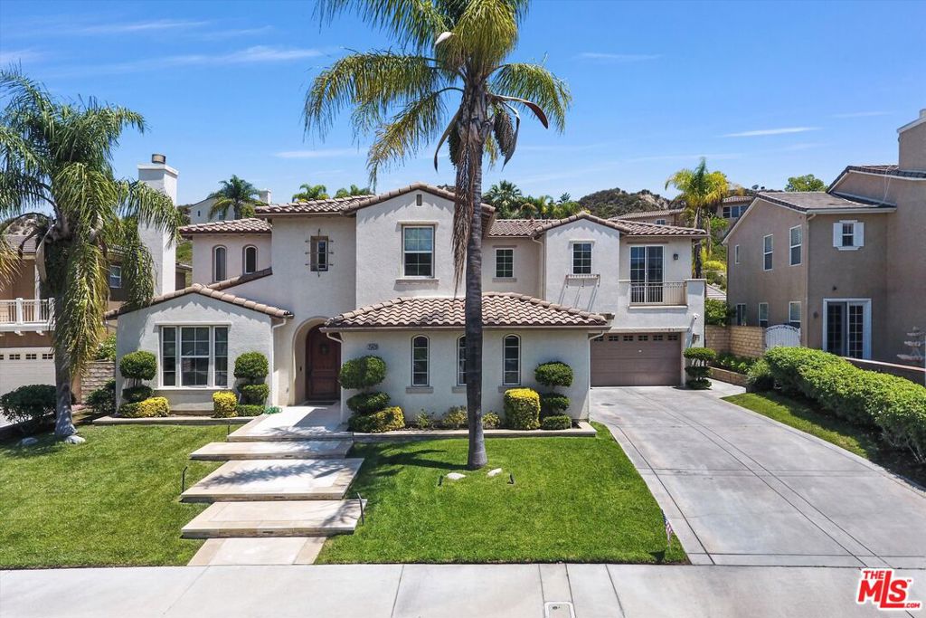 Experience luxury living in this beautifully updated 5 bedroom, 3 bath Spanish-style estate, perfectly situated in the prestigious Stevenson Ranch community. Designed for both elegance and comfort, this home offers an exceptional layout ideal for entertaining and everyday living. As you arrive, the impressive curb appeal welcomes you with lush landscaping, a palm-lined walkway, and a grand two-story entryway that sets the tone for the rest of the home. Step inside to soaring ceilings, polished marble flooring, and a light-filled formal living room anchored by a sleek modern fireplace. This home truly shines when it comes to entertaining. The chef's kitchen opens effortlessly to spacious indoor living areas and flows out to a resort-style backyard. Enjoy your own private retreat complete with a custom outdoor kitchen, a sparkling pool, and lush landscaping perfect for hosting gatherings or relaxing under the California sun. Additional highlights include a 3-car garage, spacious bedrooms, and a luxurious primary suite with spa-like amenities. The thoughtful floor plan includes one bedroom and full bath downstairs, ideal for guests or a home office. Located near award-winning schools, parks, shopping, and dining, this home offers the perfect blend of convenience, style, and privacy in one of Santa Clarita's most sought-after neighborhoods.