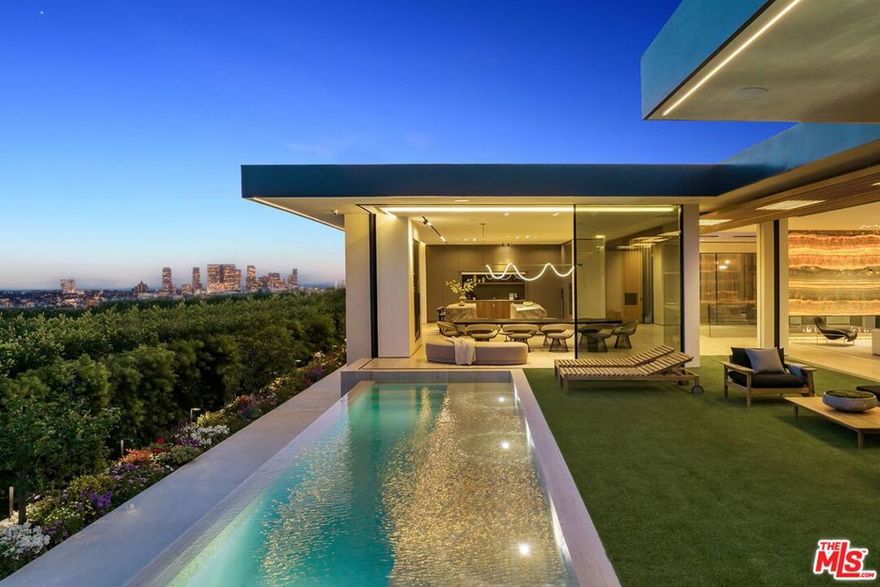 Seller willing to carry for 4% for 5 years (up to 50% of purchase price). Designed by renowned architect Paul McClean and developed by Bird Street Builders, this private sanctuary is nestled at the end of coveted Tanager Way overlooking a breathtaking, panoramic vista of shimmering city lights. Located within the prestigious Bird Streets neighborhood, the property is an exquisite modern masterpiece and embodies timeless elegance and sophistication. The impressive, open floor plan spans over 10,500 square feet, and boasts 4 bedrooms and 6 luxuriously-appointed bathrooms. Meticulously crafted with unparalleled attention to detail, this home presents an array of extraordinary amenities, elevating it to a league of its own in the vibrant heart of Los Angeles.Upon entry, the seamless integration of indoor and outdoor spaces is a testament to the property's flawless design. Showcasing the latest collection from Fleetwood, the low-profile door system creates a harmonious connection, effortlessly inviting the natural beauty of the surroundings indoors. Immaculately finished with the finest organic materials, such as travertine slab floors and a front facade that exudes timeless elegance, this residence showcases exquisite backlit onyx fireplaces and stunning white oak paneling throughout. The living area is adorned with an oversized 25-foot by 12-foot skylight, bathing the room in an abundance of natural light, with all speakers and AC ducts discreetly integrated for an enhanced aesthetic appeal. Moreover, all interior walls are adorned with Venetian Plaster, infusing a sense of warmth throughout the space. The Italian kitchen is a culinary haven for the discerning chef, featuring custom Molteni&C | Dada cabinetry and top-of-the-line appliances. The lower level of the residence is equally remarkable, housing an opulently designed fitness center and spa with sauna, movie theater, complete with fiberoptic lighting and exquisite white oak paneling, providing the perfect space for entertainment.Luxury abounds throughout every corner of this bespoke home, with notable features including Rimadesio interior doors, synonymous with unrivaled quality, and Italian stainless steel bathroom fixtures by Cea. A remarkable Antonio Lupi Bathtub with smoked translucent elegance serves as a centerpiece of indulgence.The outdoors are a haven of serenity, with wrap-around infinity-edge pool, embraced by a vast expanse of travertine slab and surrounded by lush greenery, ideal for outdoor gatherings. The expansive flat pad and grassy area provide ample space for entertainment, while a soaring living garden wall spans an impressive 60 feet by 25 feet, infusing the ambiance with an enchanting tapestry of nature. The Crestron smart home system ensures seamless efficiency and convenience, while state-of-the-art security cameras and alarm systems guarantee consummate privacy.