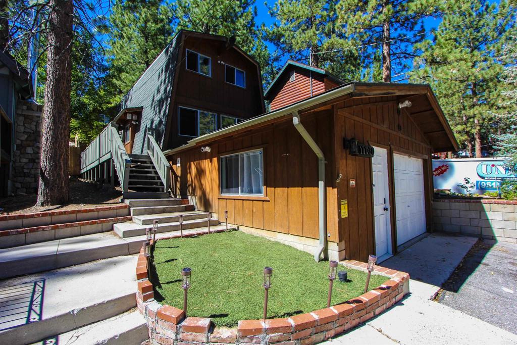 You’ll love this classic Gambrel home in the highly desirable 92314 zip code in Moonridge, near Fox Farm! Located on a quiet street with a large empty lot across the street. Conveniently near Bear Mountain, the golf course, Zoo, and the newly improved Moonridge corridor. It has stunning pine wood vaulted ceilings with appealing stained exposed beams throughout the home. Kitchen has a beautiful farmhouse sink and faucet, modern quartz countertops, and a rustic live-edge wooden breakfast bar. It is equipped with new appliances, including an added dishwasher. The tile backslash and open shelves provide a clean, modern look. The 1.5 car garage is currently used as a game room (7’ pool table with ping pong top, darts) and laundry room; potential to change to an ADU. The home features wood laminate flooring, new carpet upstairs, a brick gas fireplace, and six new electric heaters (bedrooms, garage, bathroom, in addition to the forced air heater downstairs.) A new tankless water heater in the garage has made available its closet by the front door… great for a cleaner’s or coat closet! The home has all new furniture included, providing for a turnkey short-term rental or family vacation home! Its large deck starts as you walk up to the front door, and wraps around to the backyard for your own mountain Oasis! Enjoy the large pine and oak trees surrounding the property, as you relax in the hot tub and stargaze. Complete with outdoor shed for tools, snow shovel, etc. Bistro lights surround deck walkway as well as pergola over hot tub – including outdoor table and patio chair set. Home is equipped and monitored with full ADT security system – Five cameras with a wall unit control center and kitchen display. 2 nest smart locks on front and garage doors… Lets unlock the door to your dream home!