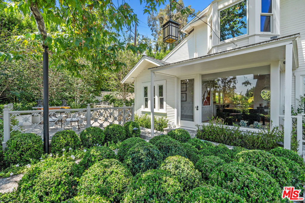 Welcome to a hidden gem conveniently located above the Sunset Strip. Tucked behind private gates and surrounded by beautifully landscaped gardens, this home offers exceptional privacy, refined design, and effortless indoor-outdoor flow. Step inside this 1920's California cottage that blends historic character with a re-imagined open layout. An inviting living room with pleasant views is centered around a traditional marble fireplace and opens out to an enchanting covered veranda providing an ideal spot for morning coffee or evening cocktails. The dining room is surrounded by walls of glass overlooking peaceful garden views, perfect for intimate gatherings or festive dinners. The heart of the home is the cook's kitchen combining beauty with functionality and featuring quartz countertops, shaker cabinetry, center island and built in appliances including a Sub-Zero fridge. A bookcase-lined guest bedroom and bathroom complete the home's main level. An extra large Primary Suite spans the entire second floor with vaulted beamed ceilings, panoramic views, and a cozy office nook with bay window provides an inspiring work-from-home space. The luxurious en-suite bath includes dual sinks, a soaking tub, and separate walk-in shower. The impressive grounds are a masterclass in curated outdoor living. Enjoy the lush gardens, winding stone pathways, tranquil fountains and thoughtfully designed outdoor living spaces. Entertain effortlessly outdoors with a Wolf-equipped built-in grilling station, stone fire pit and distinctive Hollywood Regency style pavilion that is perfect for al fresco dining or starlit gatherings. This home is located moments from West Hollywood, Beverly Hills and LA's premier dining, shopping and entertainment. This is more than a home - it's a retreat. Escape the city without leaving it.