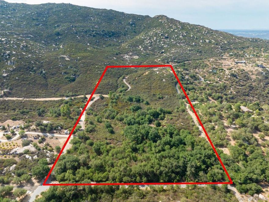 Nestled in the foothills of iconic Mount Woodson, this expansive 20.39-acre parcel offers a rare canvas for visionaries, builders, or investors. With sweeping panoramic views, rolling terrain, and multiple natural view corridors, the land invites possibilities ranging from a custom dream estate to agricultural ventures aligned with its A70 Limited Agriculture zoning. The property falls within the Rural Lands (RL-20) designation, providing opportunities for a single-family residence, crop cultivation, or animal use, with the flexibility to create a true country retreat. While no specific development studies have been completed, the topography and size allow for immense design potential. Utilities are nearby, and the property sits within the Ramona Municipal Water District with county fire protection service in place. For those seeking privacy, acreage, and views while remaining within easy reach of San Diego’s metro and coastal communities, This Woodson Crest parcel represents both a lifestyle investment and a long-term opportunity. Electrical lines run along the perimeter of the property lot. Municipal water currently runs along Salida Del Sol - per the water dept. there is a process and cost for the ability to get a meter on the property, but its very convenient that the water line runs along the northern perimeter of the property. Ramona in general uses propane tanks for typical gas use and all homes in this area are serviced by Septic Systems, with little exception. Take full advantage of this opportunity to fully express your architectural creativity with this gorgeous estate property.